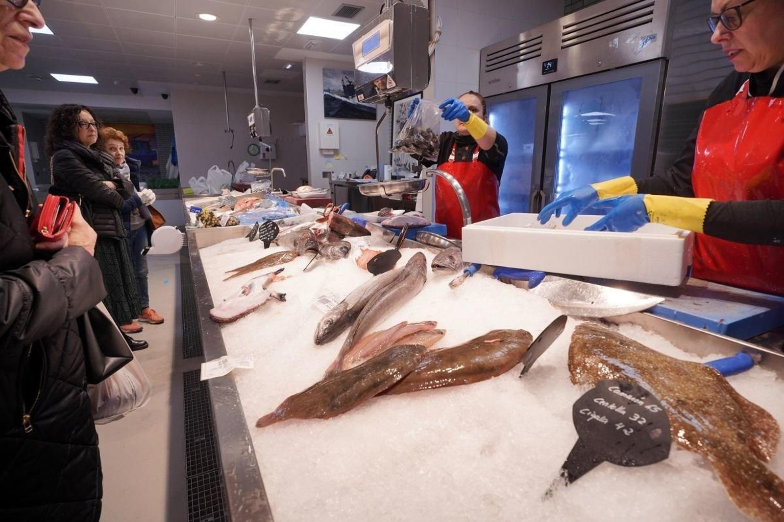 Clientes haciendo cola ayer en una pescadería en el mercado de O Progreso.