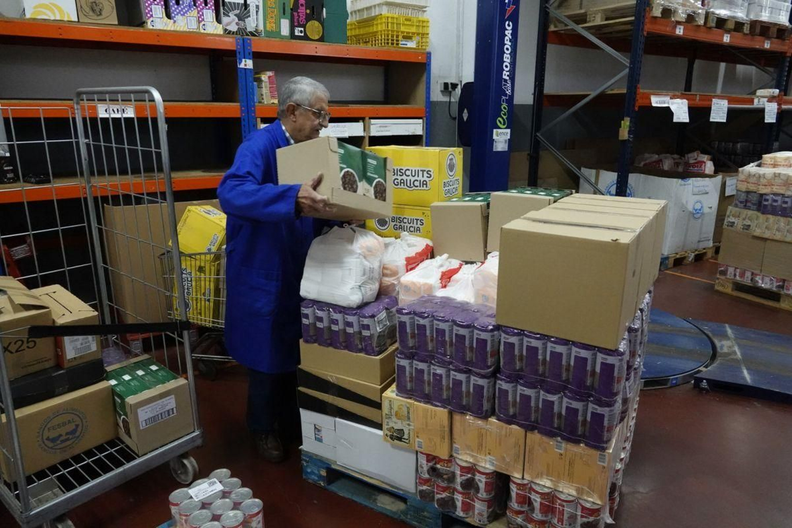 Un voluntario del Banco de Alimentos de Vigo coloca la comida a repartir en el almacén de la entidad.