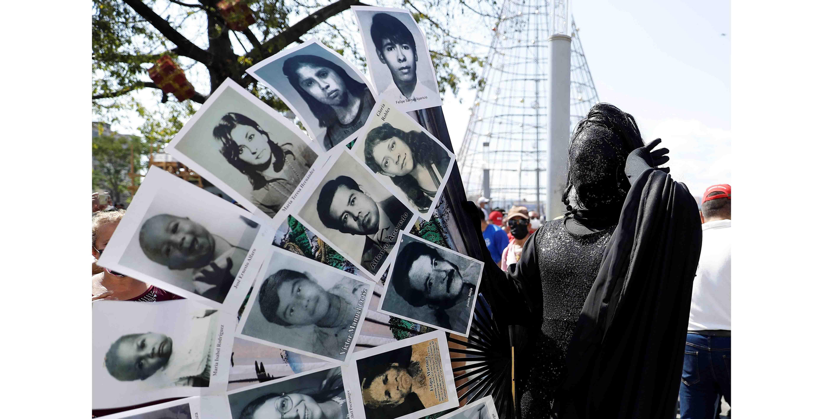 Lady Drag, personaje creado por Marvin Pleitéz, participa con un atuendo formado por un abanico con rostros de civiles asesinados o desaparecidos en el conflicto armado durante unas protestas durante la conmemoración de los 30 años de la firma de los Acuerdos de Paz, en San Salvador (El Salvador). EFE/ Rodrigo Sura