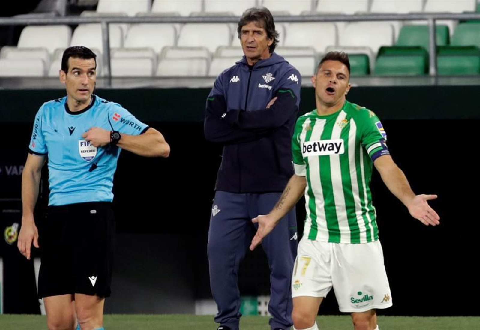 Manuel Pellegrini (c), técnico chileno del Real Betis, observa a su jugador Joaquín Sánchez "Joaquín" (d) hablando con el árbitro Martínez Munuera