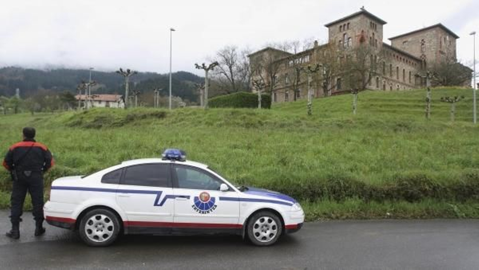Un miembro de la Ertzaintza vigila la zona de la explosión.
