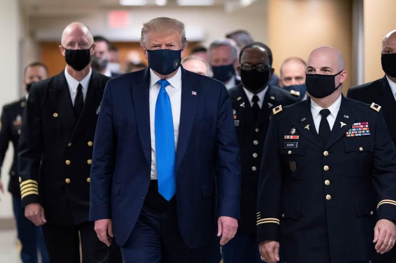 Trump, con  máscara, acompañado por un grupo de militares en Bethesda, Maryland.