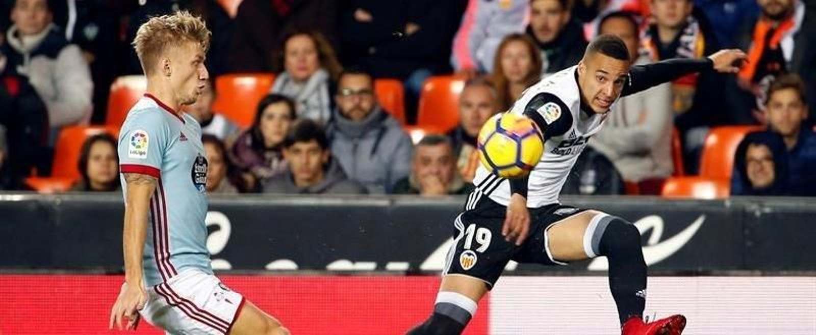 El delantero del Valencia Rodrigo Moreno (d) pasa un balón ante el danés Daniel Wass, del Celta