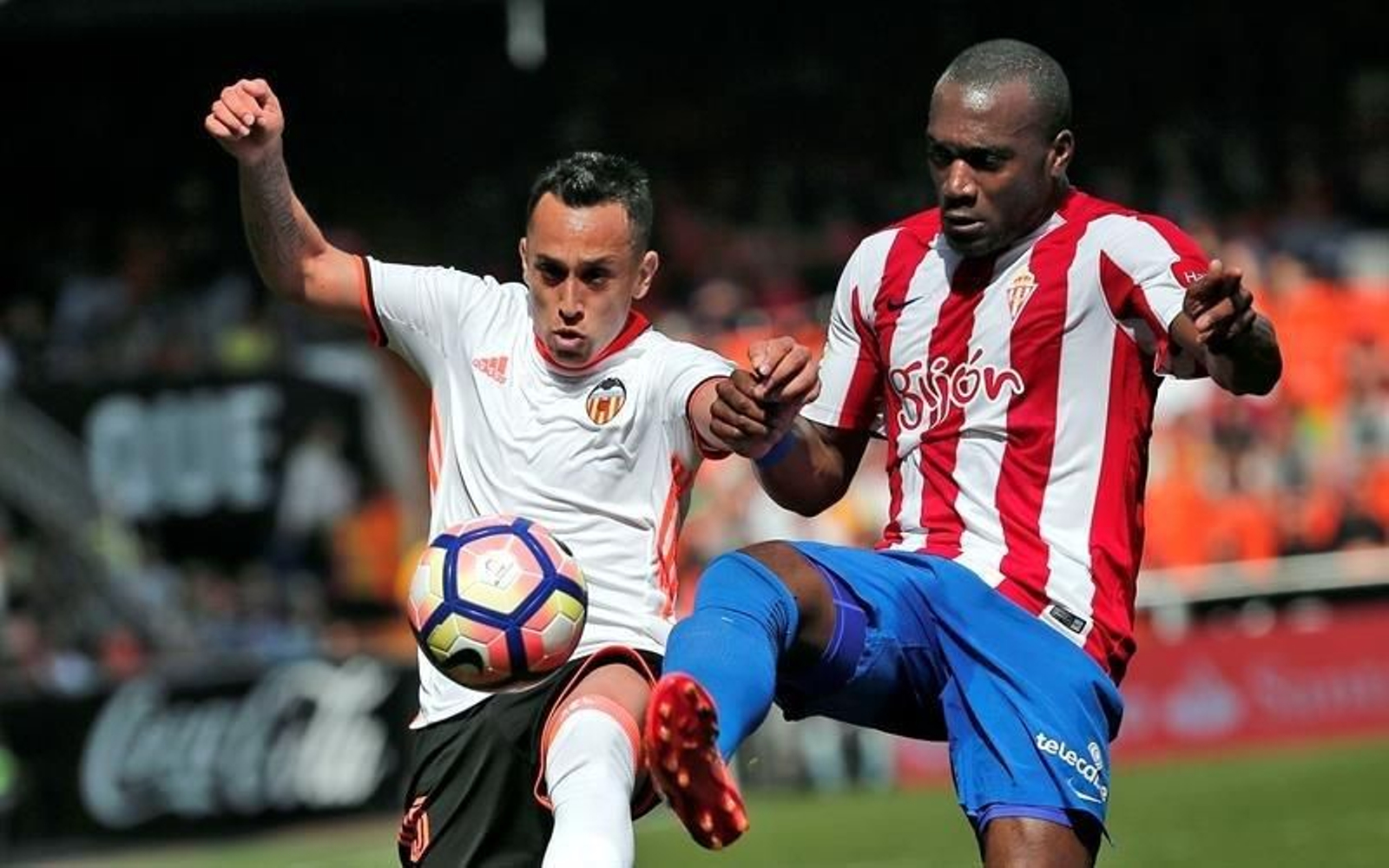 El centrocampista chileno del Valencia Fabián Orellana (i) disputa un balón con el defensa francés del Sporting de Gijón Jean Sylvain Babin (d)