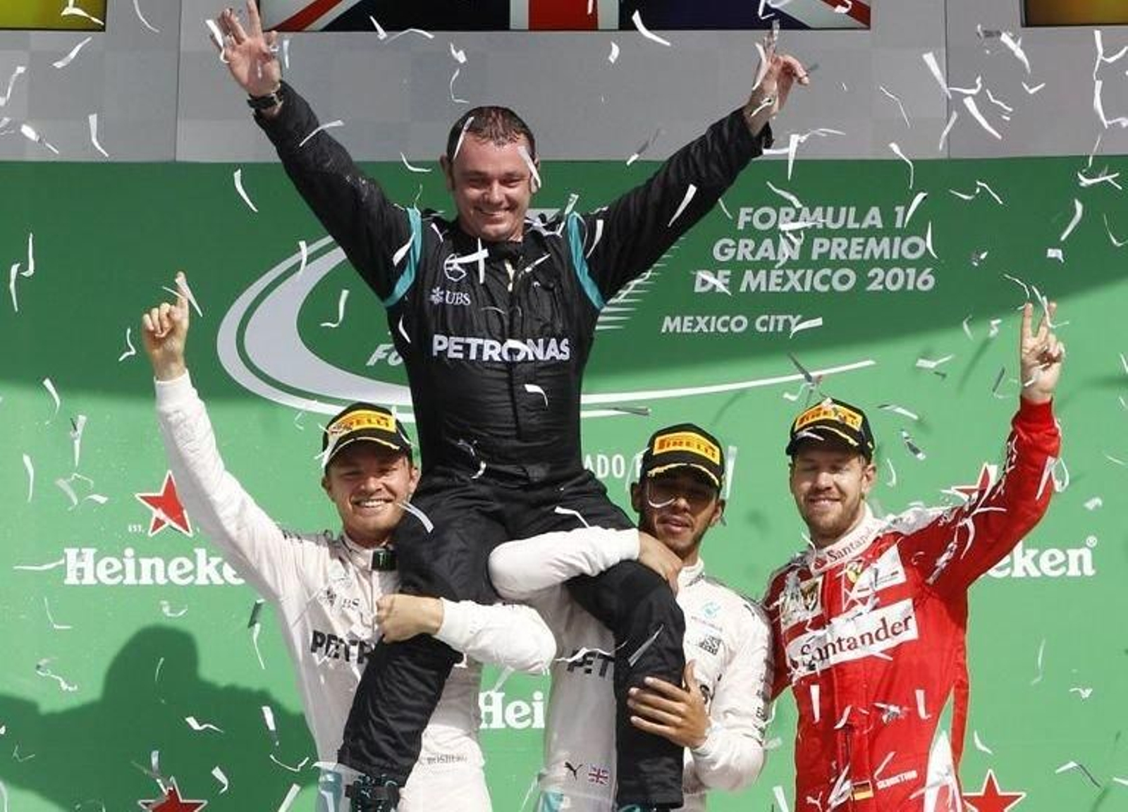 Rosberg y Hamilton sujetan al coordinador de Mercedes, Tony Walton, junto a Vettel en el podio.