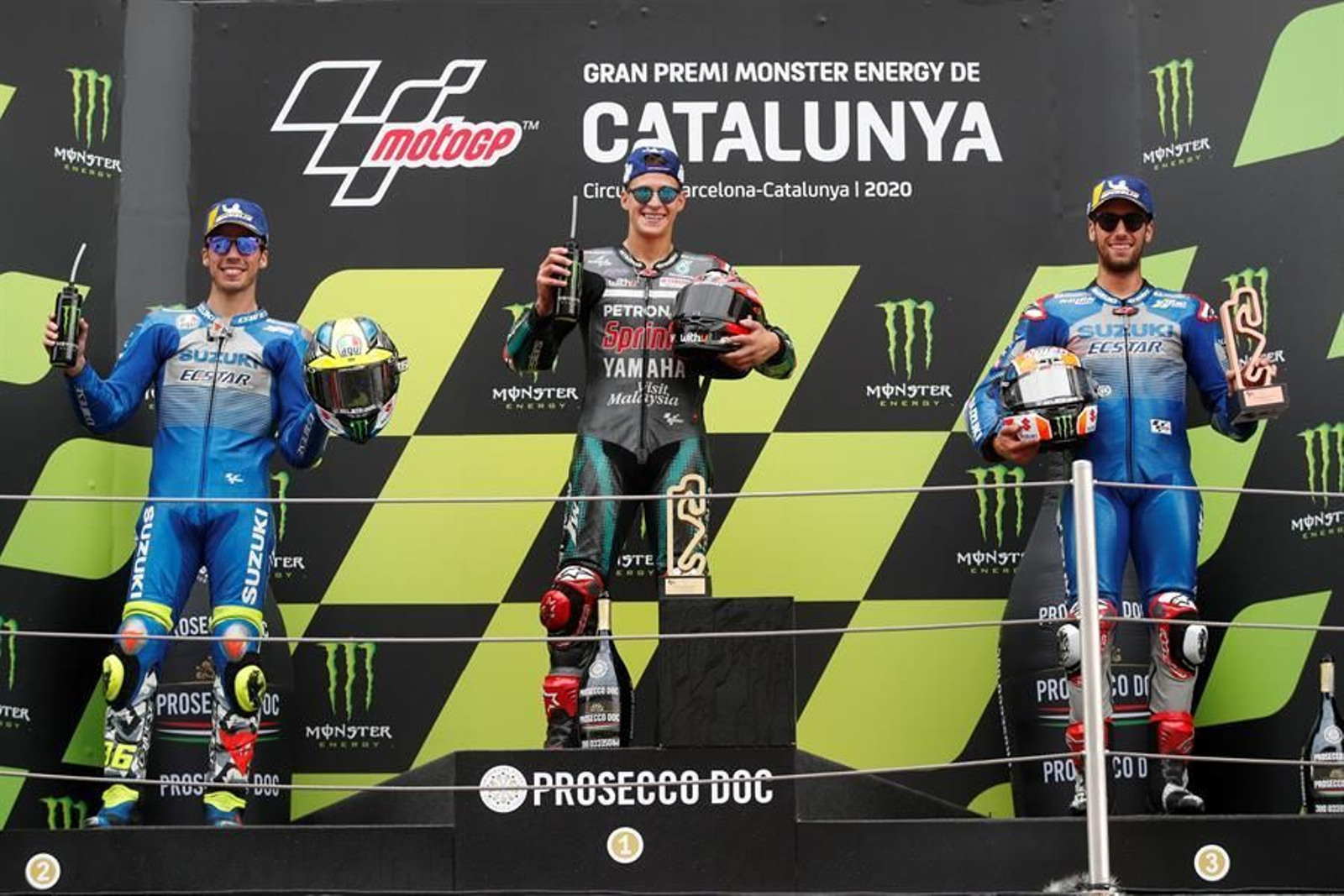 El piloto francés de Petronas Yamaha, Fabio Quartararo, acompañado de los españoles de Suzuki, Joan Mir (i) y Alex Rins (d), en el podio