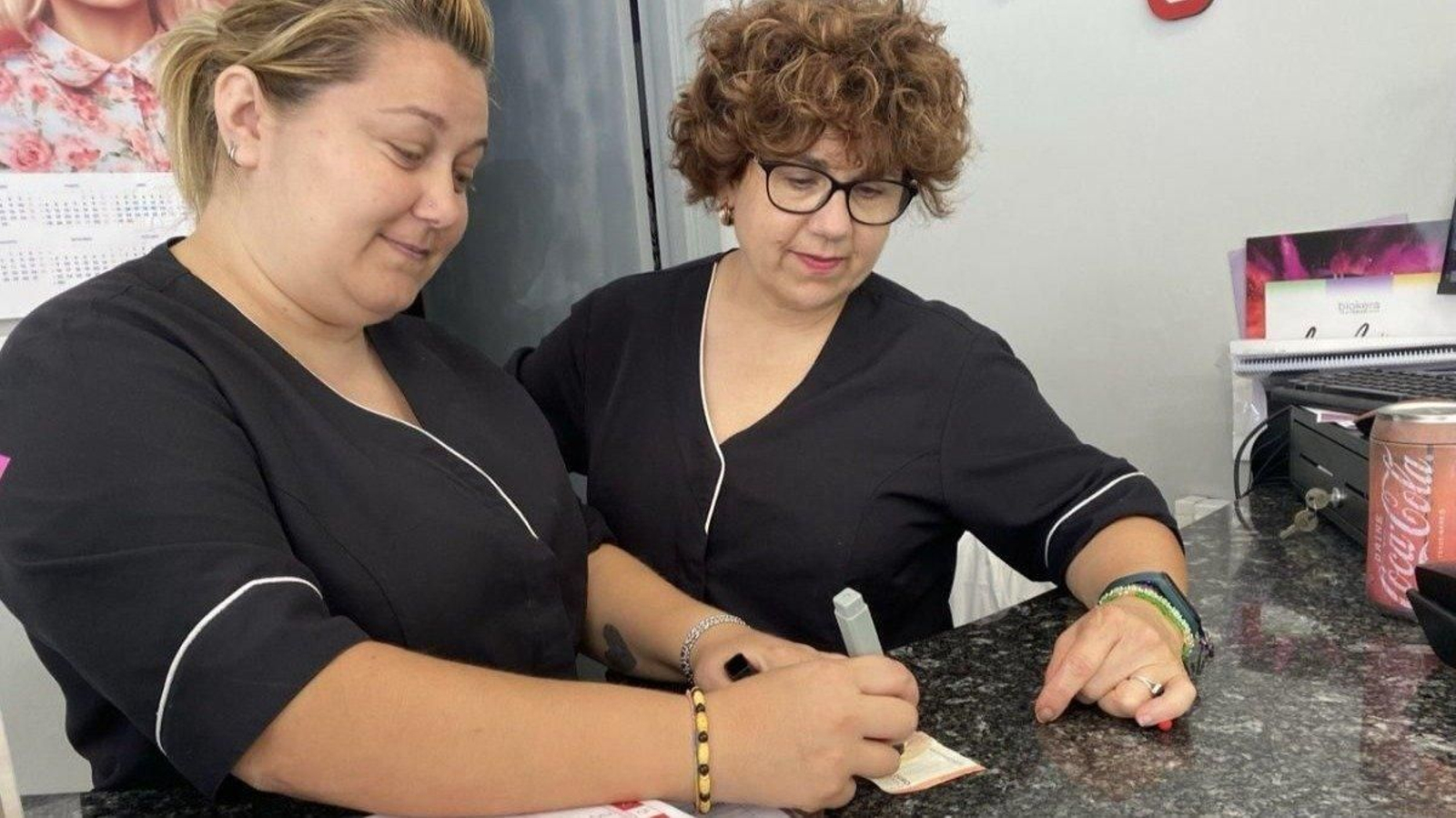 Marta y Lourdes comprueban con un rotulador detector si un billete es auténtico.