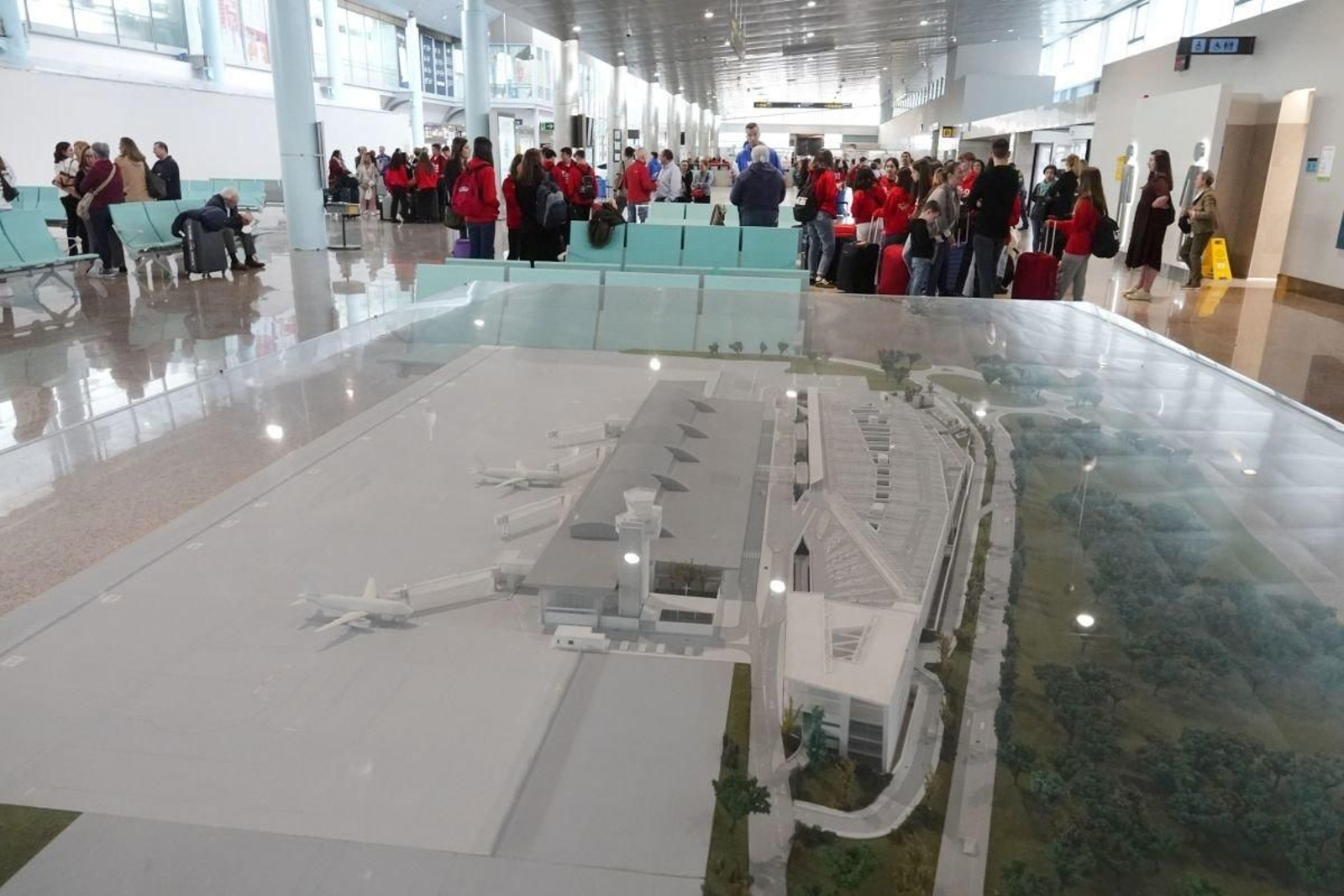 Una maqueta del aeropuerto dentro de la terminal viguesa. Al fondo, pasajeros esperando embarcar a su destino.