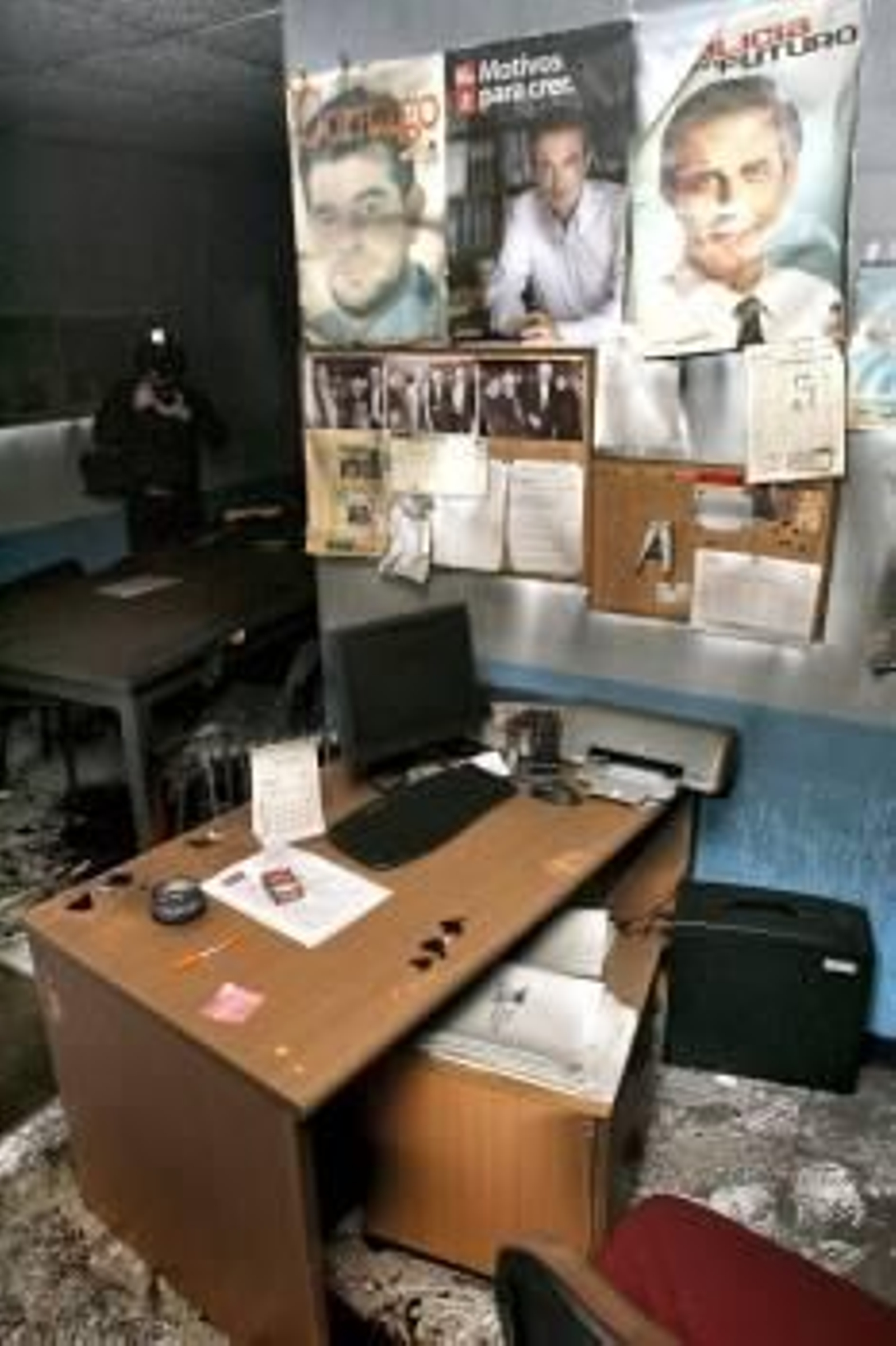 Un fotógrafo toma imágenes de los desperfectos en la sede del PSdeG en Carral. (Foto: CABALAR)