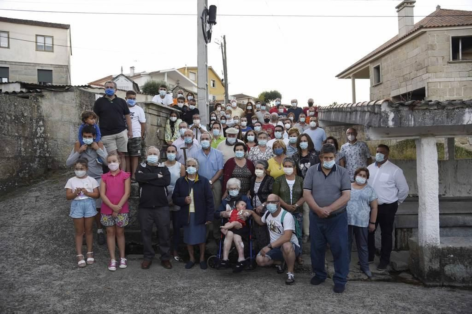 Os veciños do barrio do Vilar, en Matamá, fotografaron xunto a fonte co gallo do seu centenario.