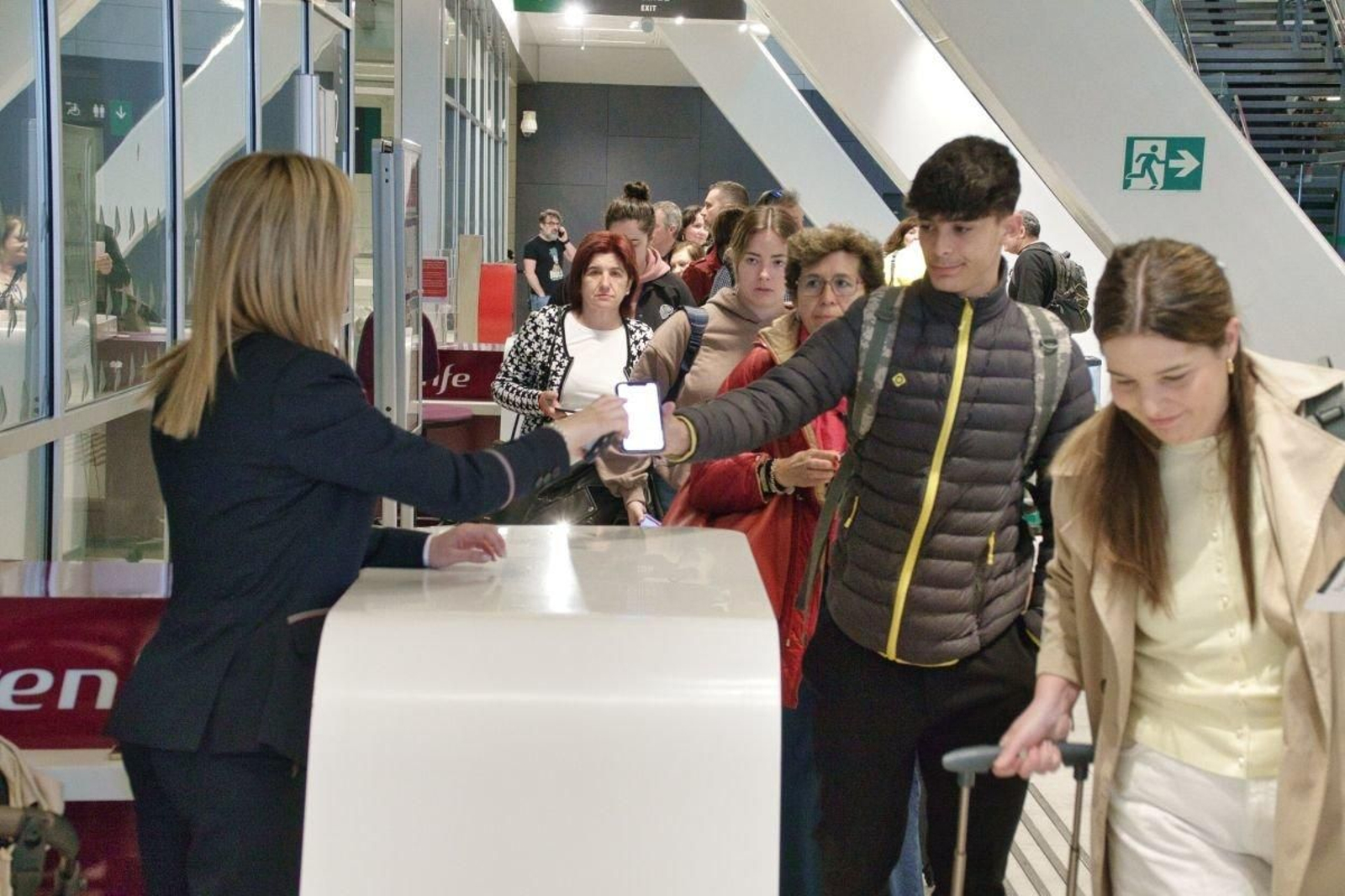 Pasajeros mostrando sus billetes en la estación de Urzaiz antes de partir.