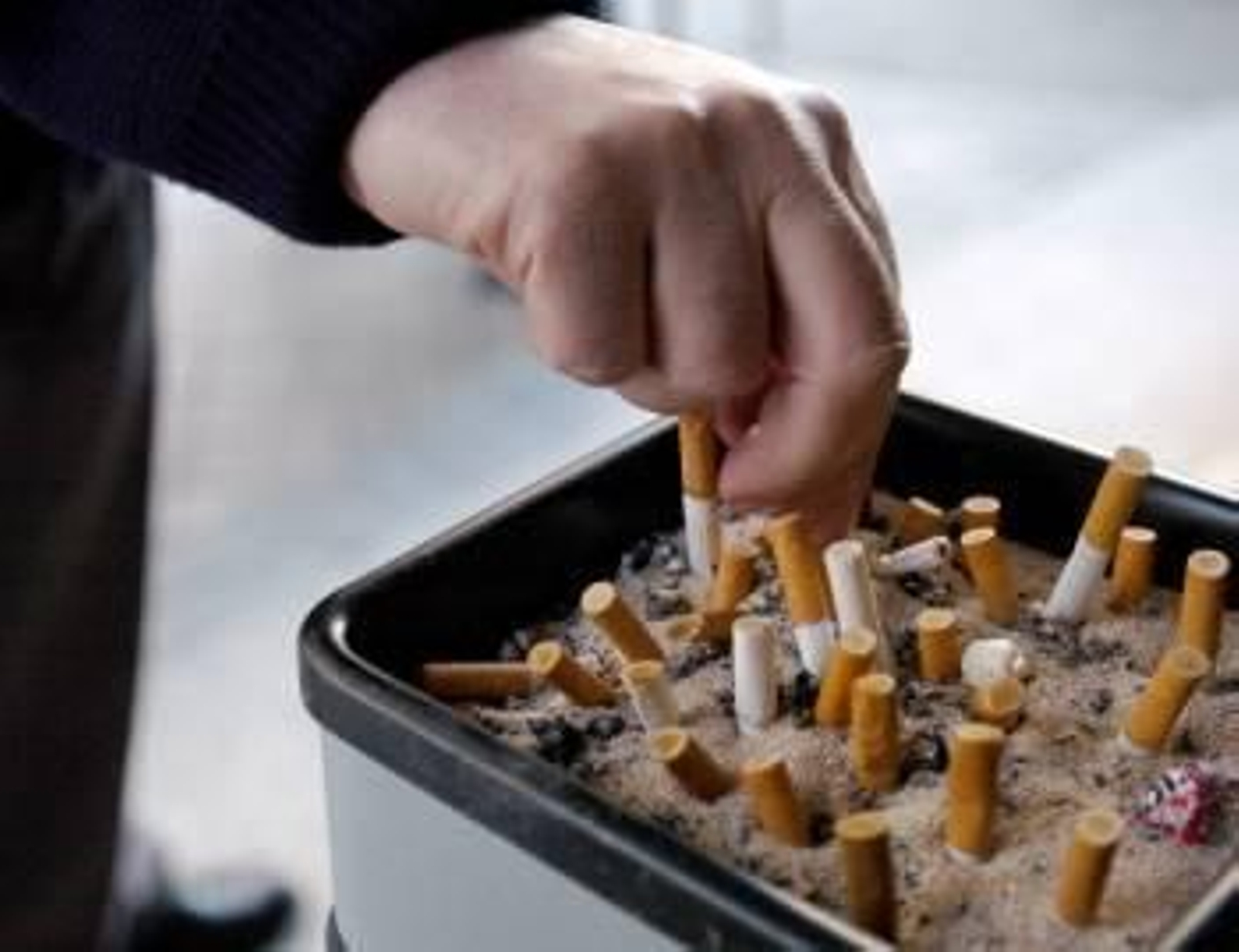 Un ciudadano apaga un cigarrillo en un cenicero público. (Foto: ARCHIVO)
