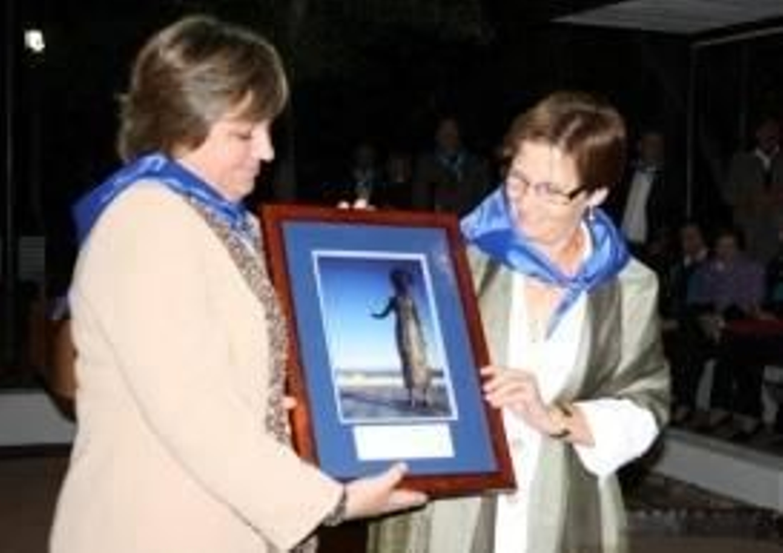 María José Ramos, consejera de Presidencia, Justicia e Igualdad del Principado de Asturias entrega un cuadro recordatorio con la imagen de la madre emigrante a la Presidenta de la Colectividad Asturiana de Chile, Carmen Gloria de Diego.
