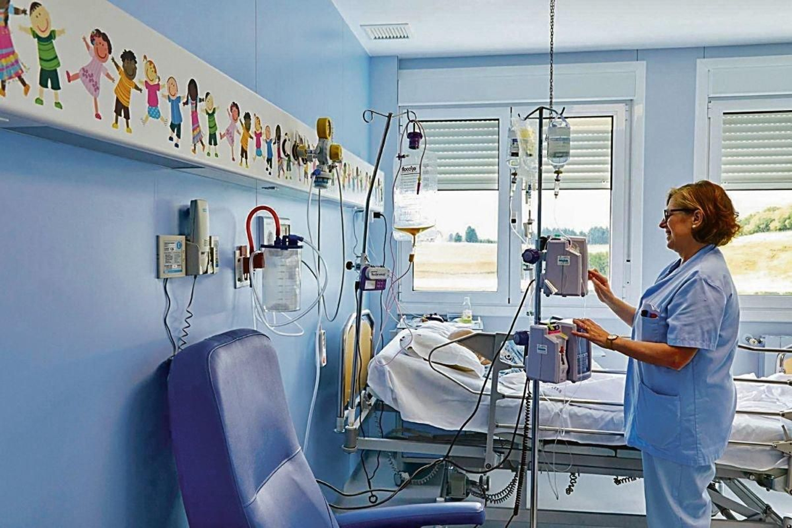 Una sanitaria atiende a un menor con cáncer.