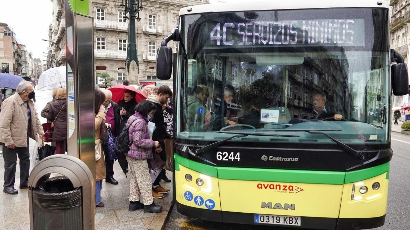 Viajeros subiéndose al autobús en una céntrica parada de Vigo.