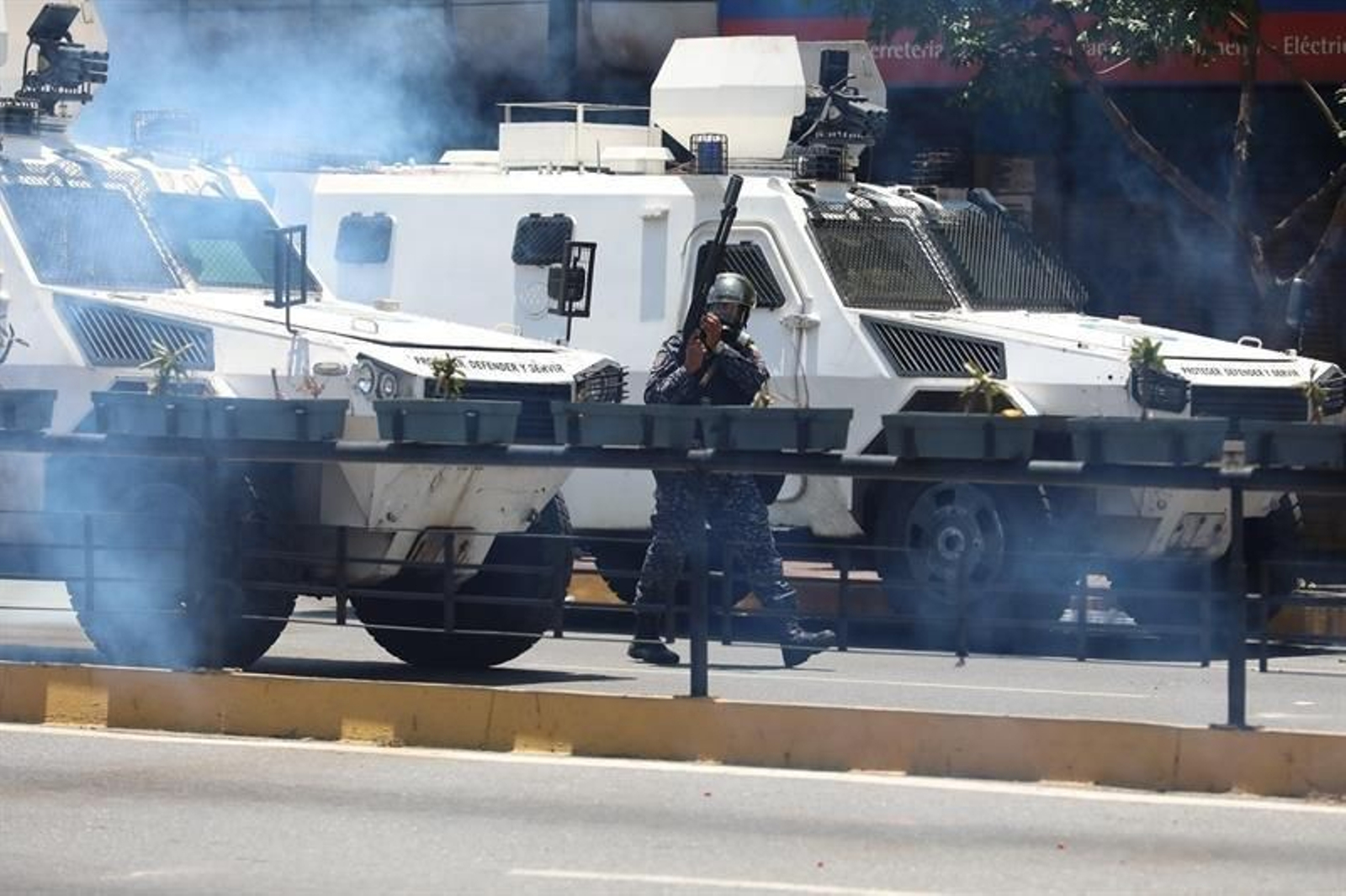 Vista de tanquetas y miembros de la Policía Nacional Bolivariana mientras tratan de bloquear el paso de una manifestación