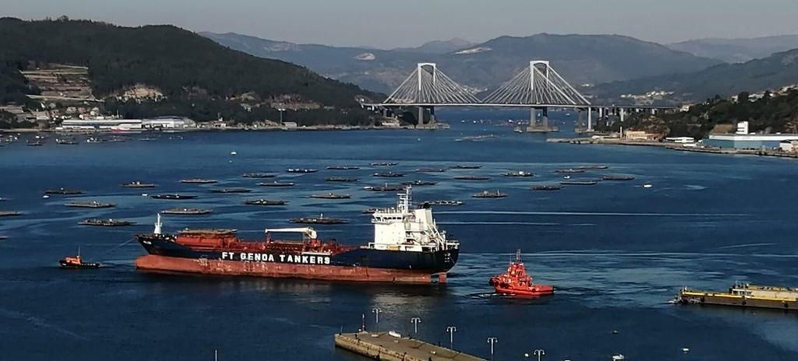 Un barco-tanque abandonando ayer el puerto vigués ayudado por remolcadores.