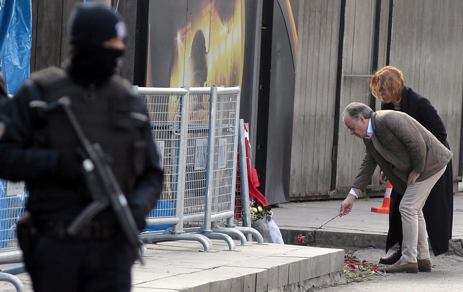 Una papreja deposita flores frente a la entrada de la discotca "Reina", protegida por policías turcos.