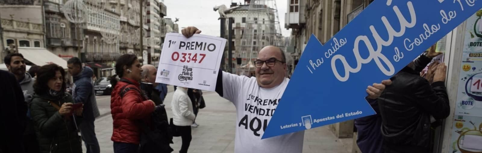 El lotero de la Porta do Sol de Vigo muestra el décimo premiado con el Gordo de Navidad // Vicente Alonso