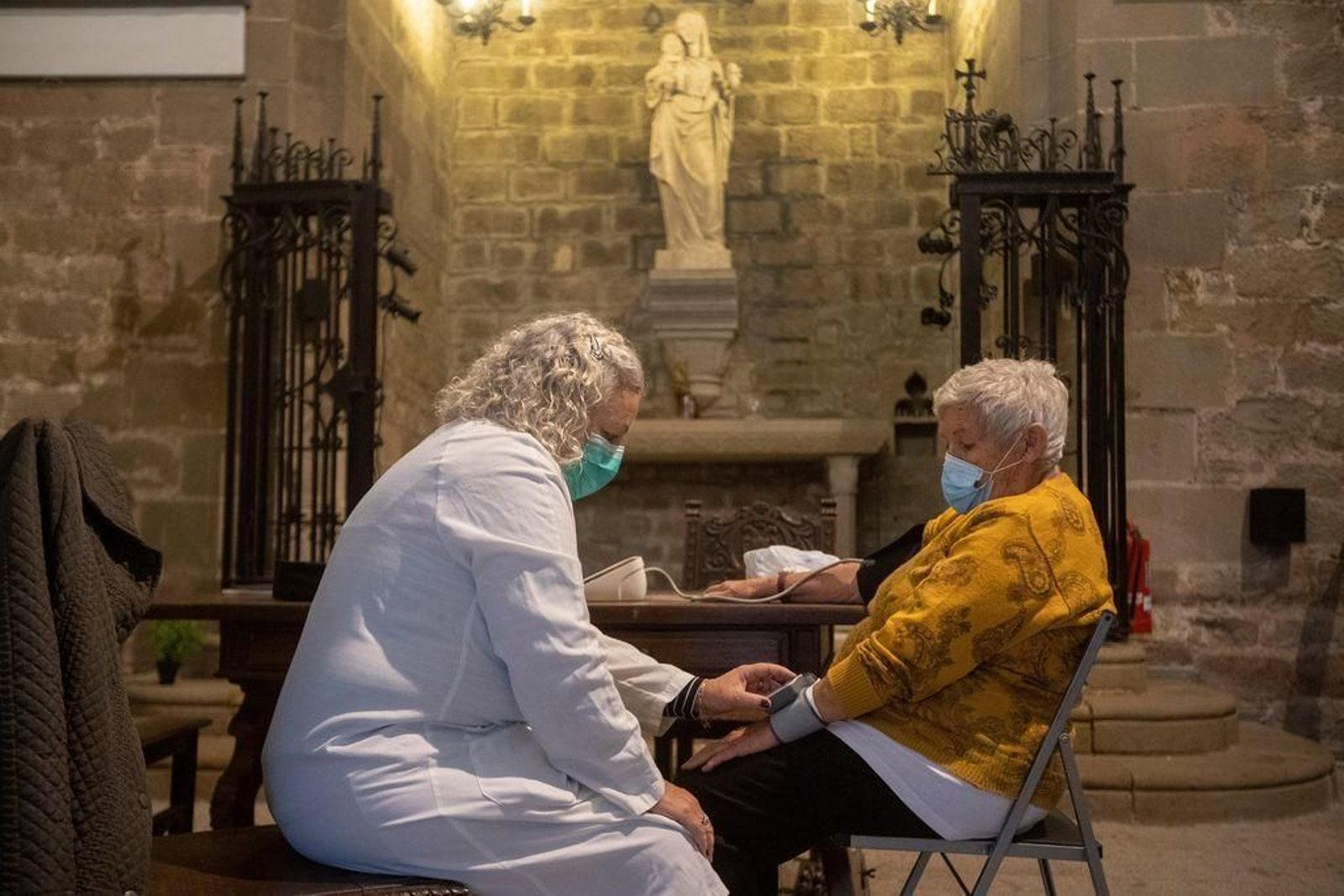 Una sanitaria atiende a una persona sin recursos en la parroquia de Santa Anna de Barcelona.