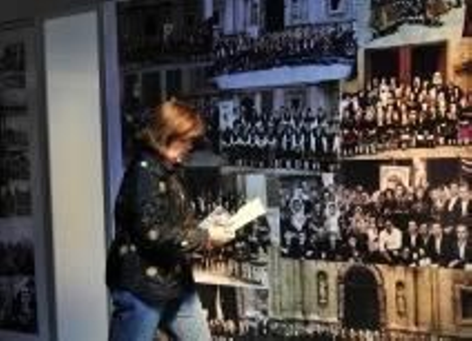 Una mujer observa varias fotografías antiguas.