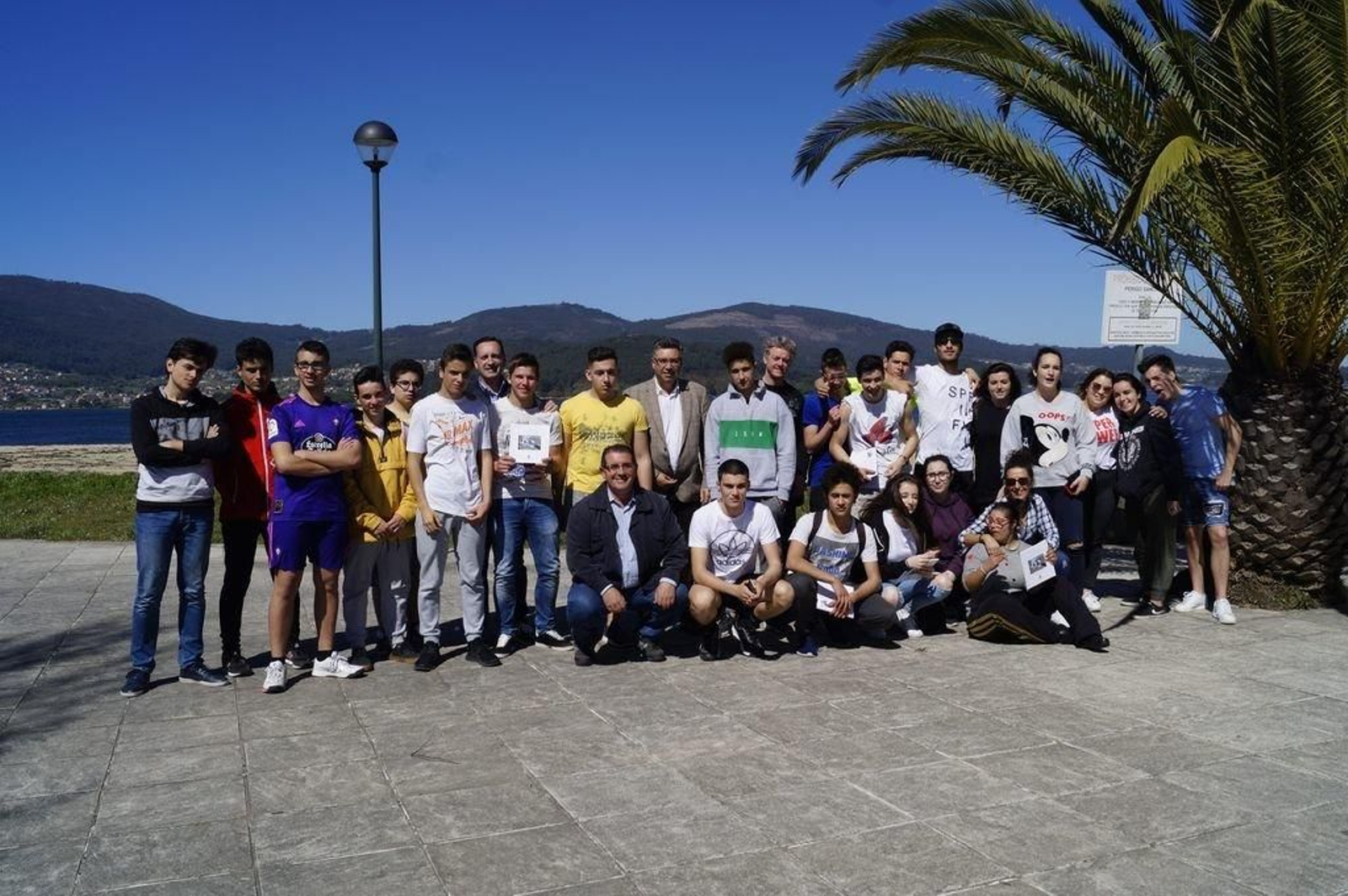 El alcalde y el concejal de Medio Ambiente con el grupo de alumnos que participó en la limpieza de la playa.