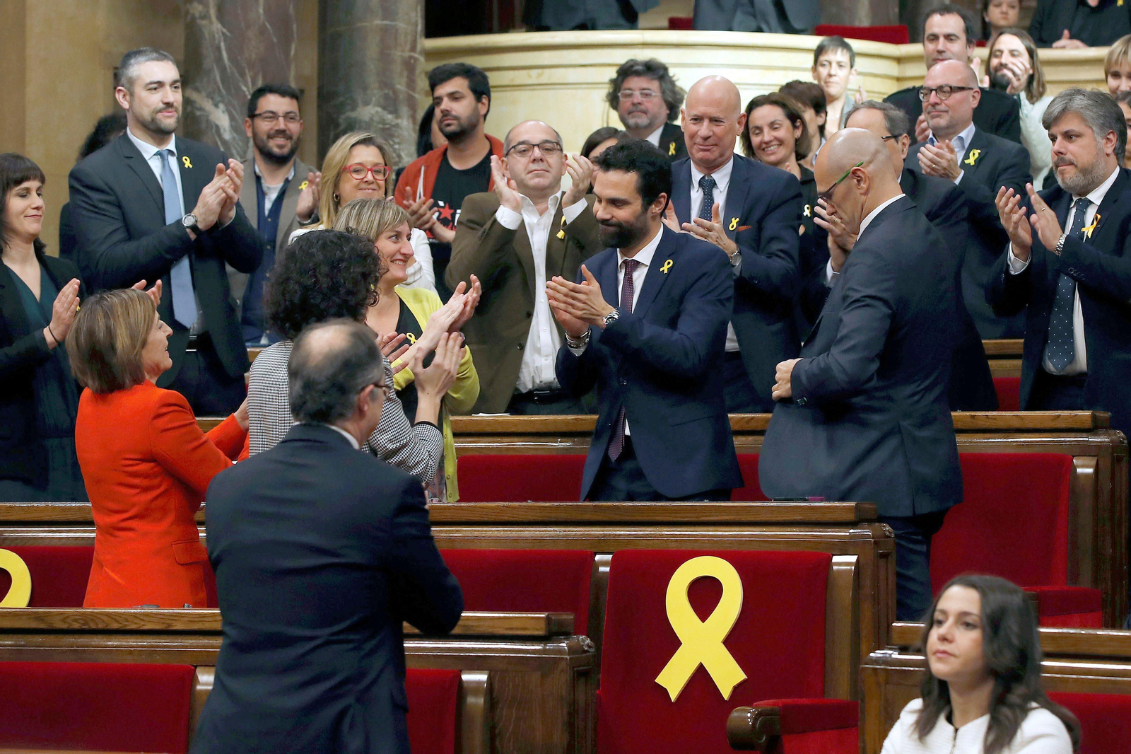 El nuevo presidente del Parlament, Roger Torrent, recibe la felicitación de sus compañeros en la Cámara.