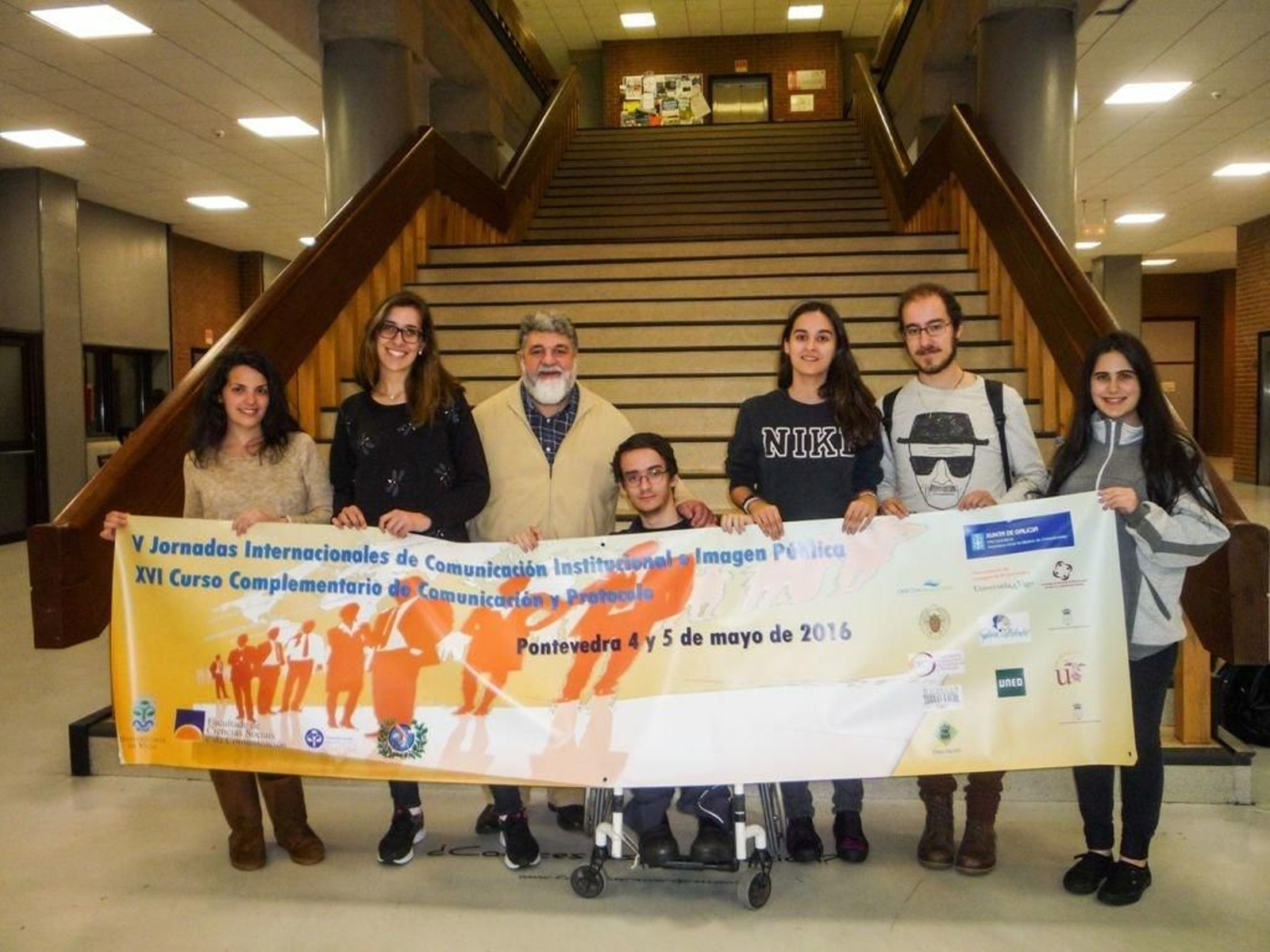 El profesor Fernando Ramos, en el centro, con el cartel de las jornadas.