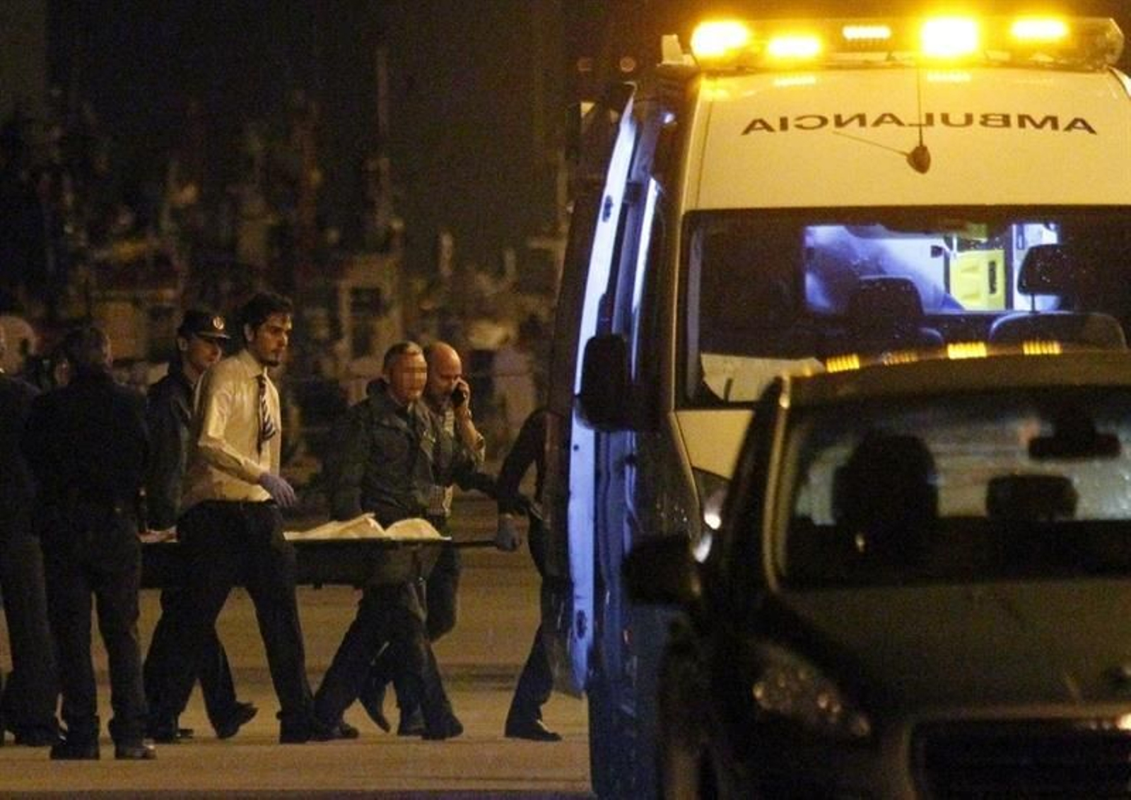 Agentes de la Guardia Civil y de los servicios funerarios trasladan los restos mortales de una de las cuatro personas