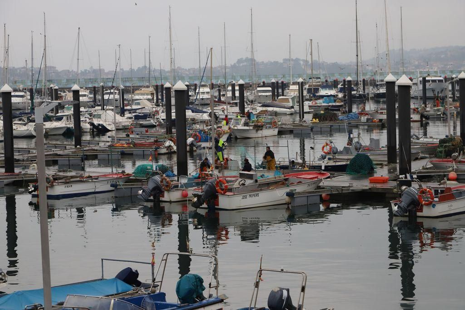 Barcos amarrados y marineros en tierra