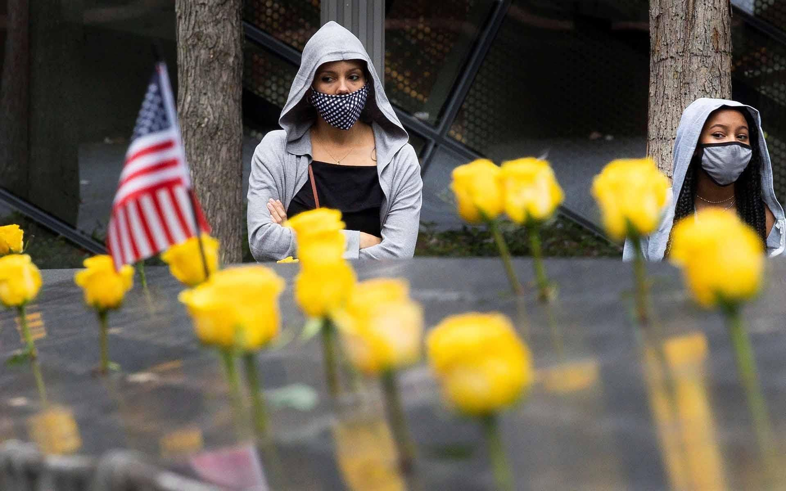 Mujeres con tapabocas participan en el homenaje del Día de los Veteranos en Nueva York. EFE/Justin Lane