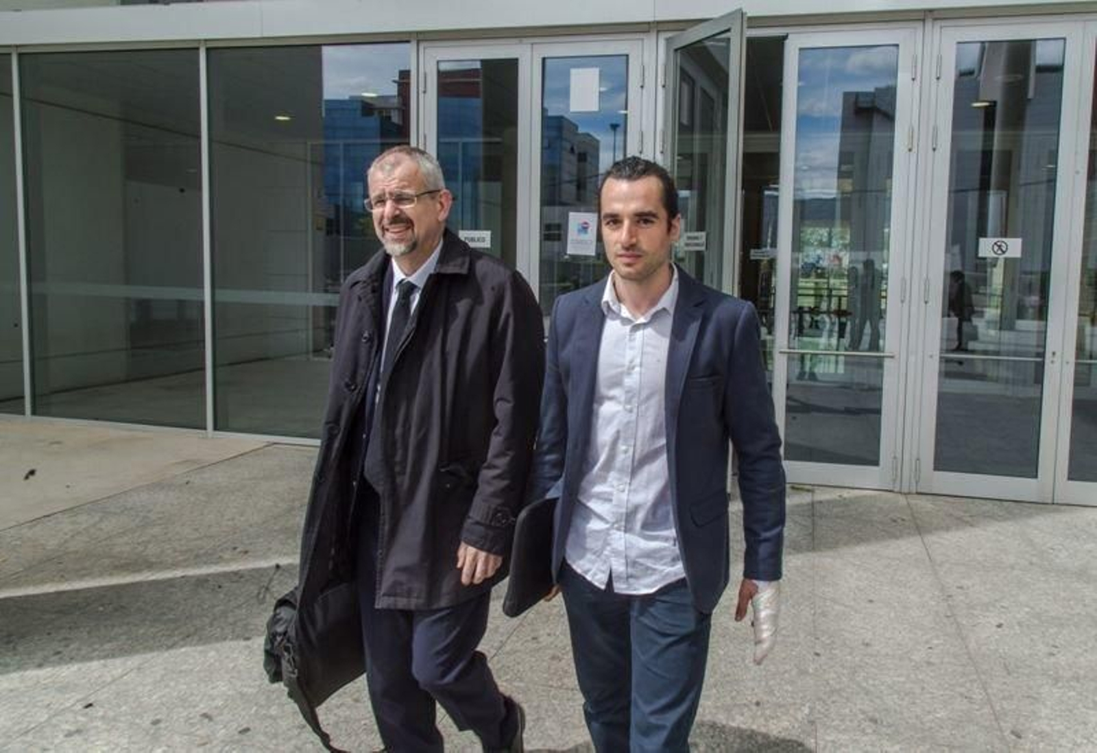 El creador de la web, Alberto García Sola, sale de los juzgados junto a su abogado.