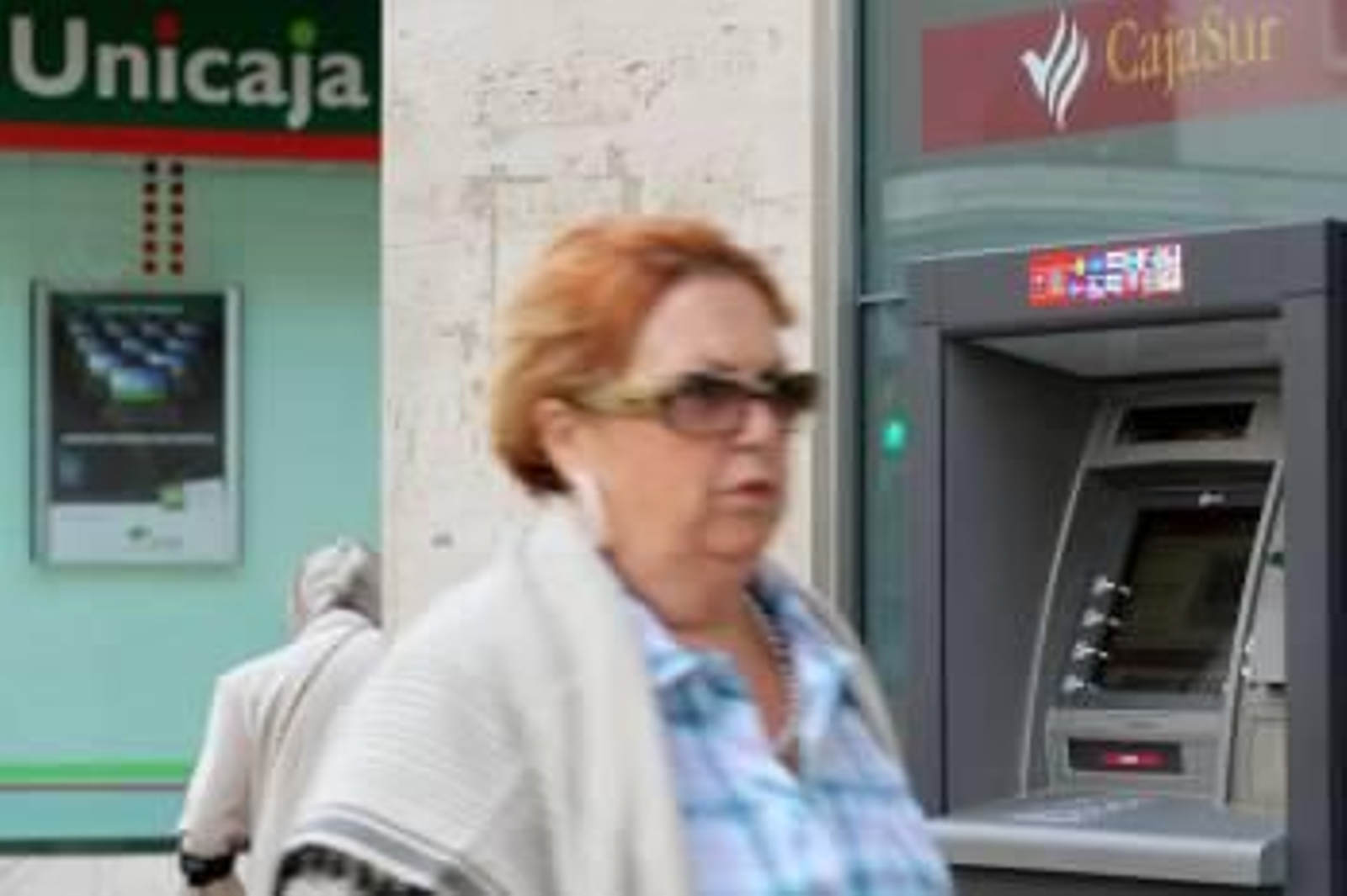 Una señora delante de un cajero de CajaSur.