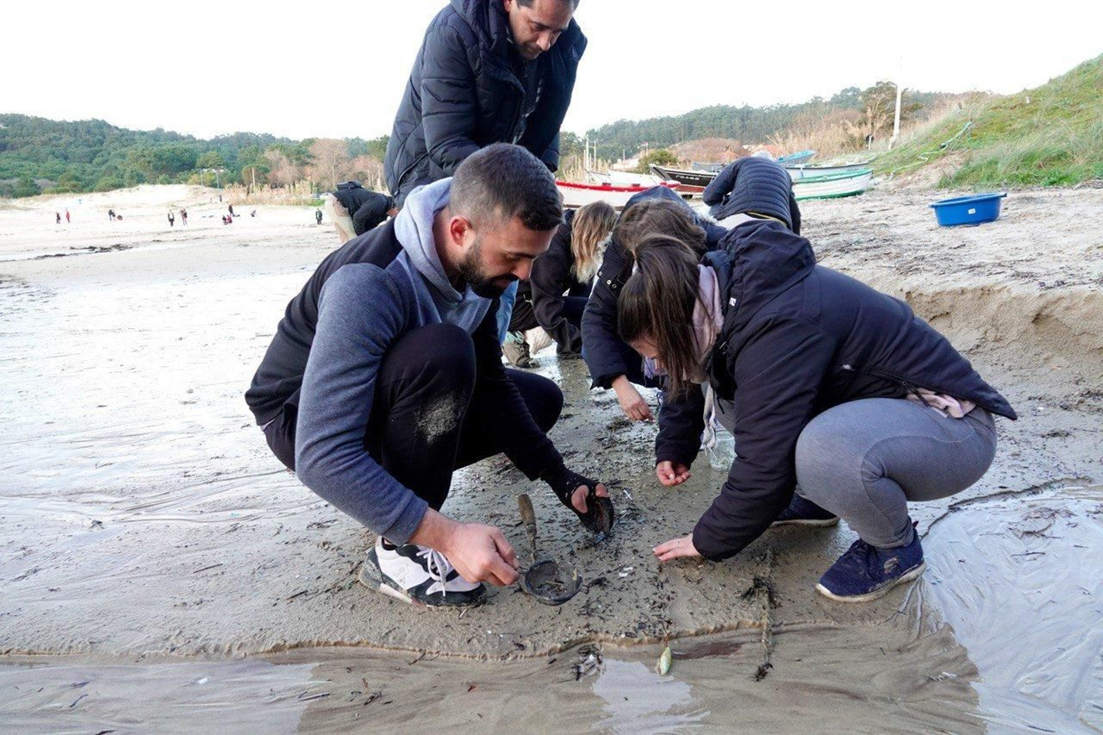 Voluntarios recogen pellets de plástico.