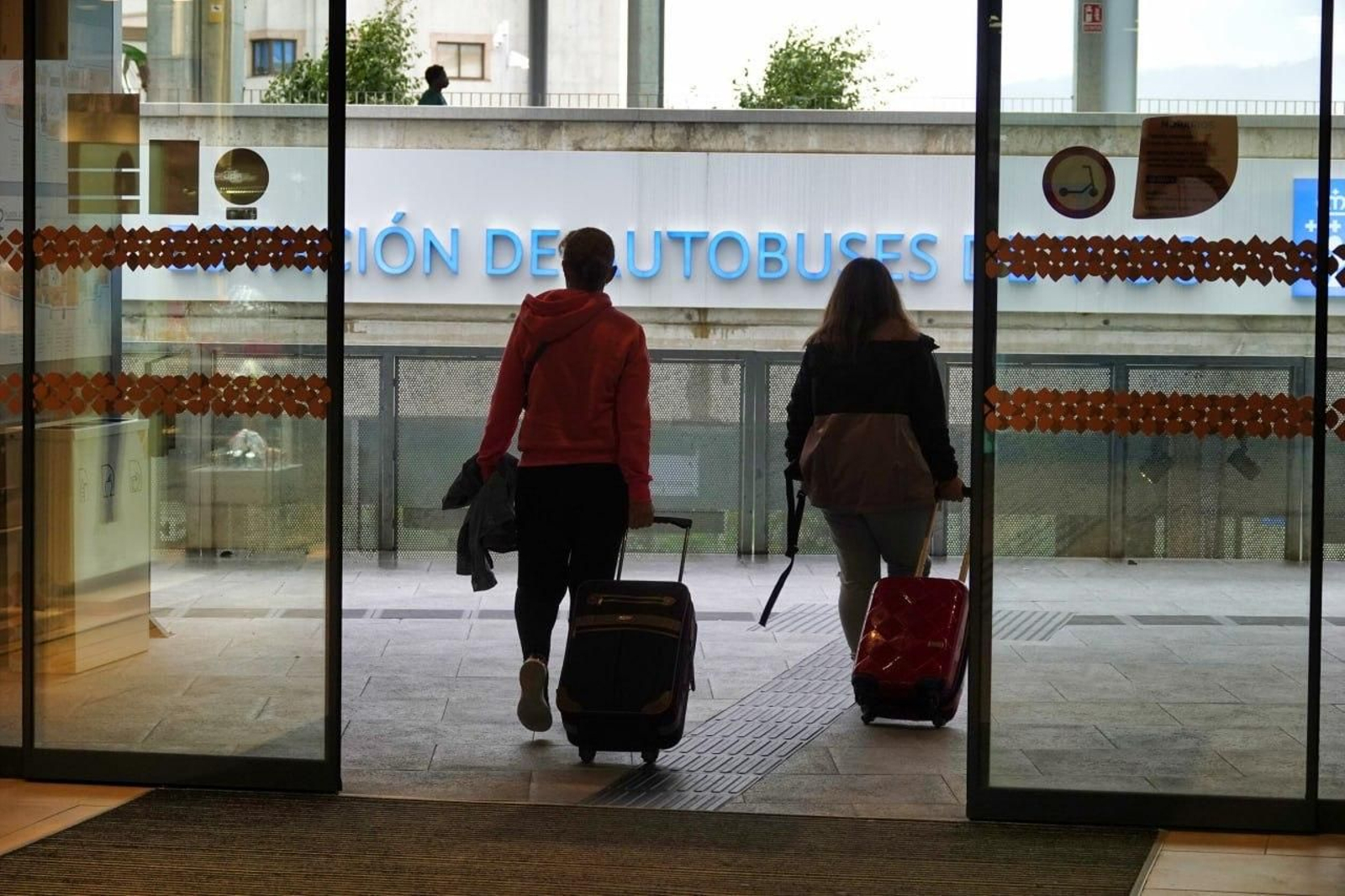 Dos viajeros con maleta en la estación de autobuses de Vigo. // Vicente Alonso