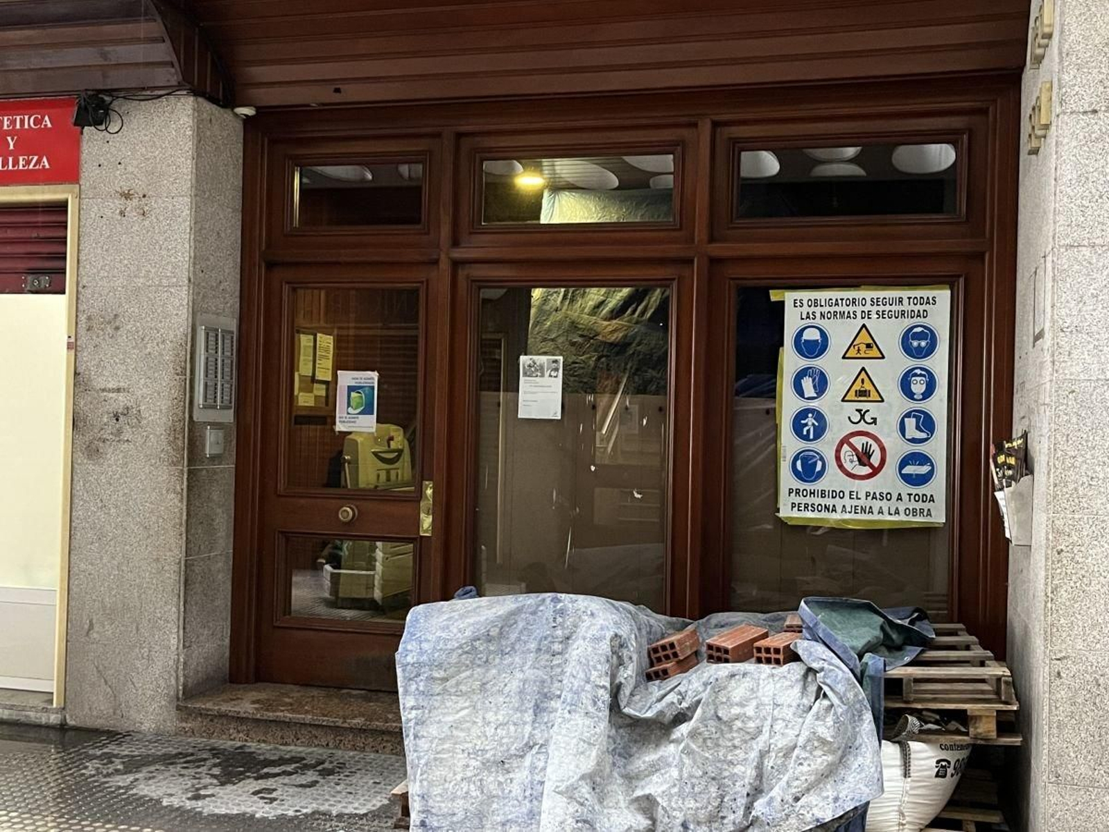Un portal en la ciudad, con material de construcción por una reforma en su interior.
