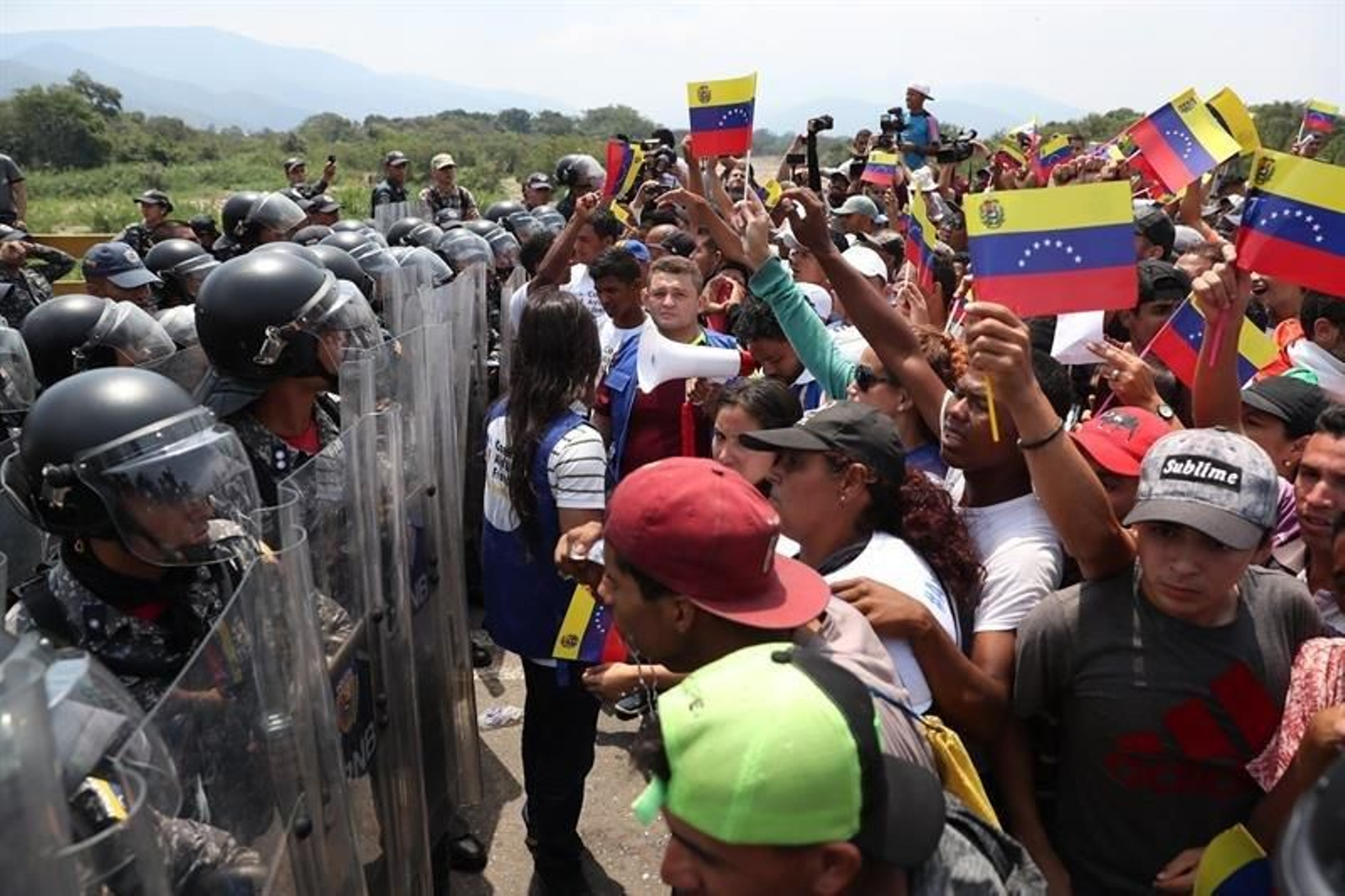 Vista de cientos de civiles apostados en el Puente Internacional Simón Bolívar frente a la Policía venezolana