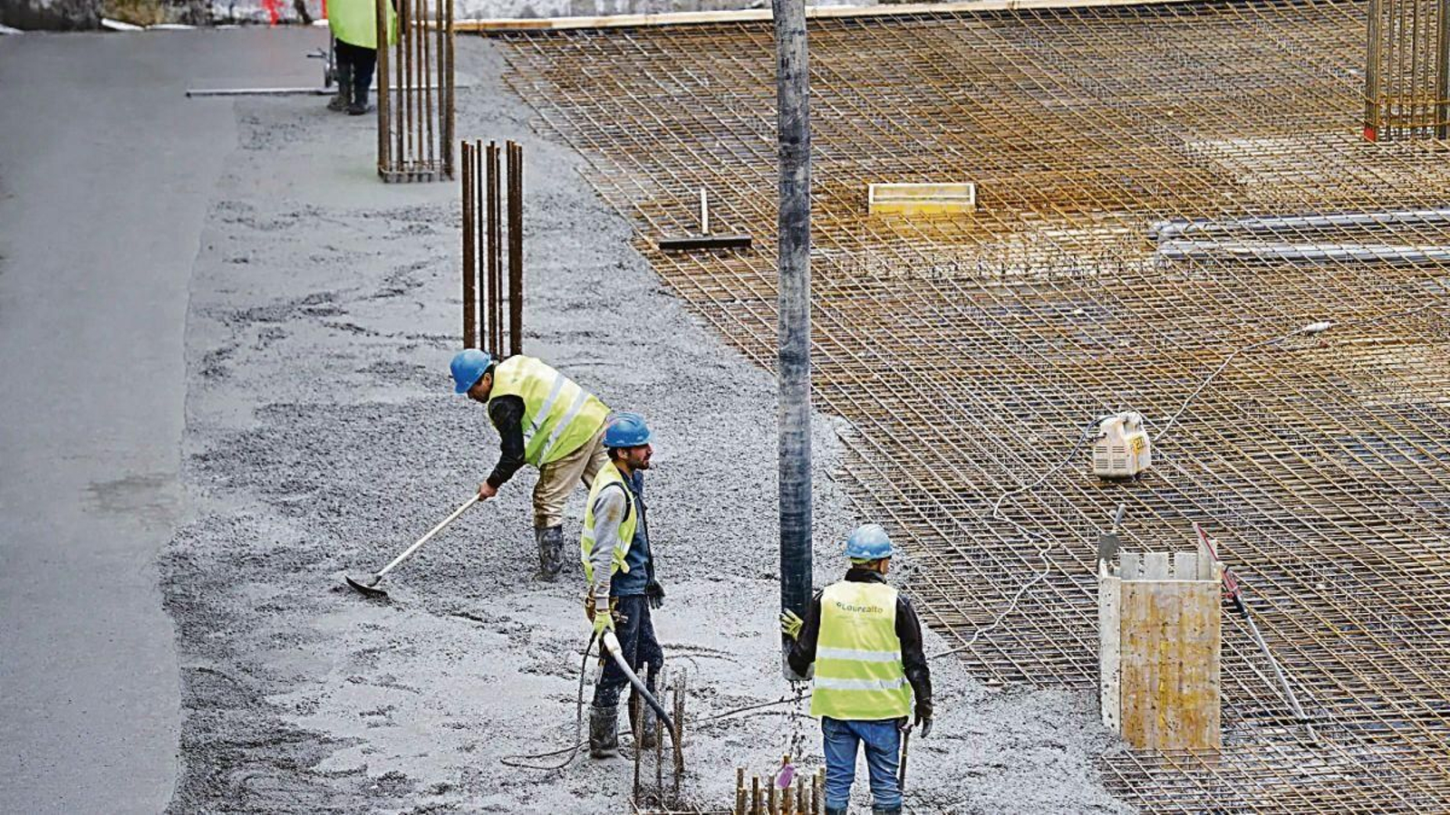 Un grupo de obreros trabaja en un solar de viviendas.