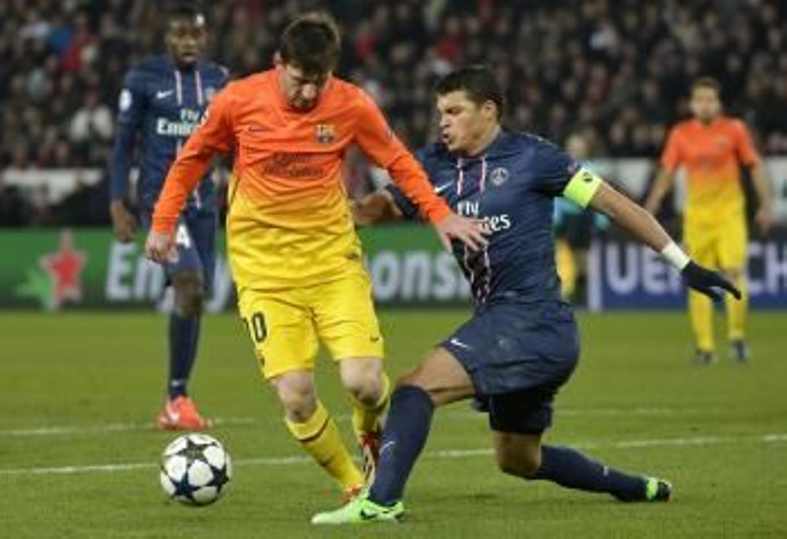 Messi, que se tuvo que retirar en el descanso por lesión, trata de superar la presión del central del PSG Thiago Silva.