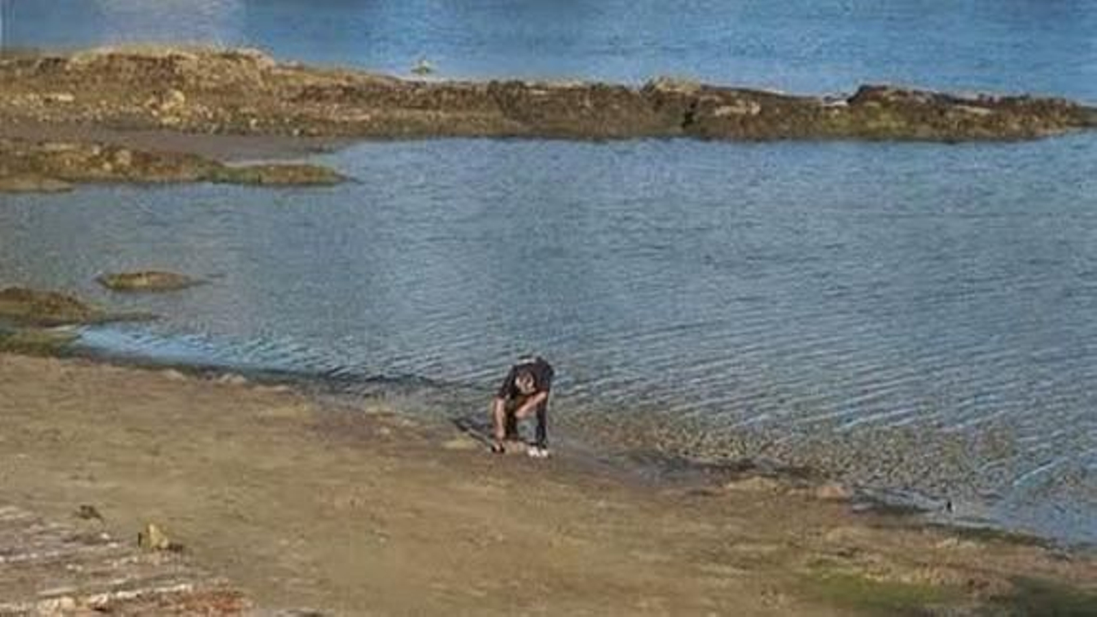El hombre sorprendido cogiendo las almejas en el arenal de Bouzas y bolsa incautada.