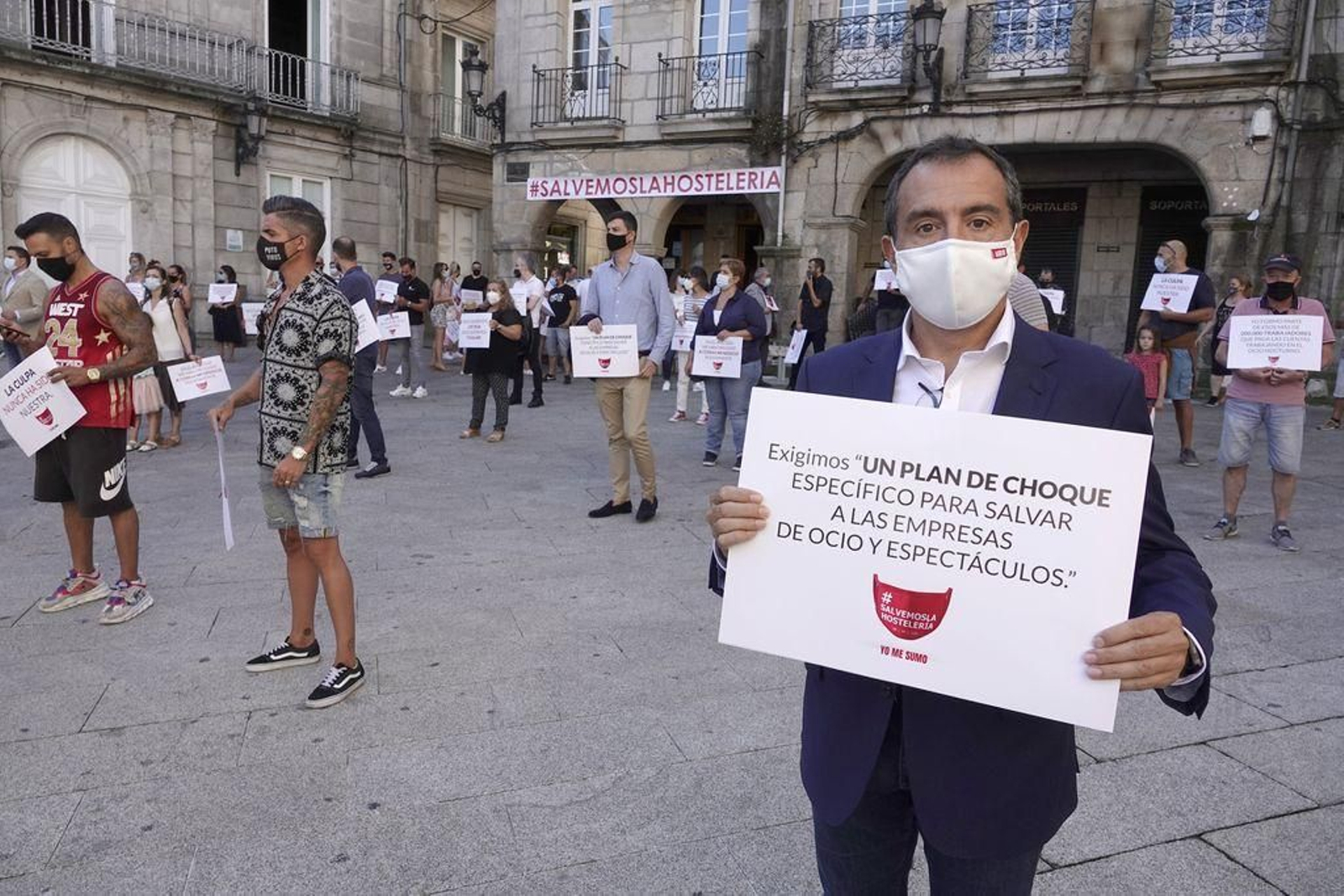 César Sánchez Ballesteros muestra una de las pancartas utilizadas por los hosteleros en la concentración.