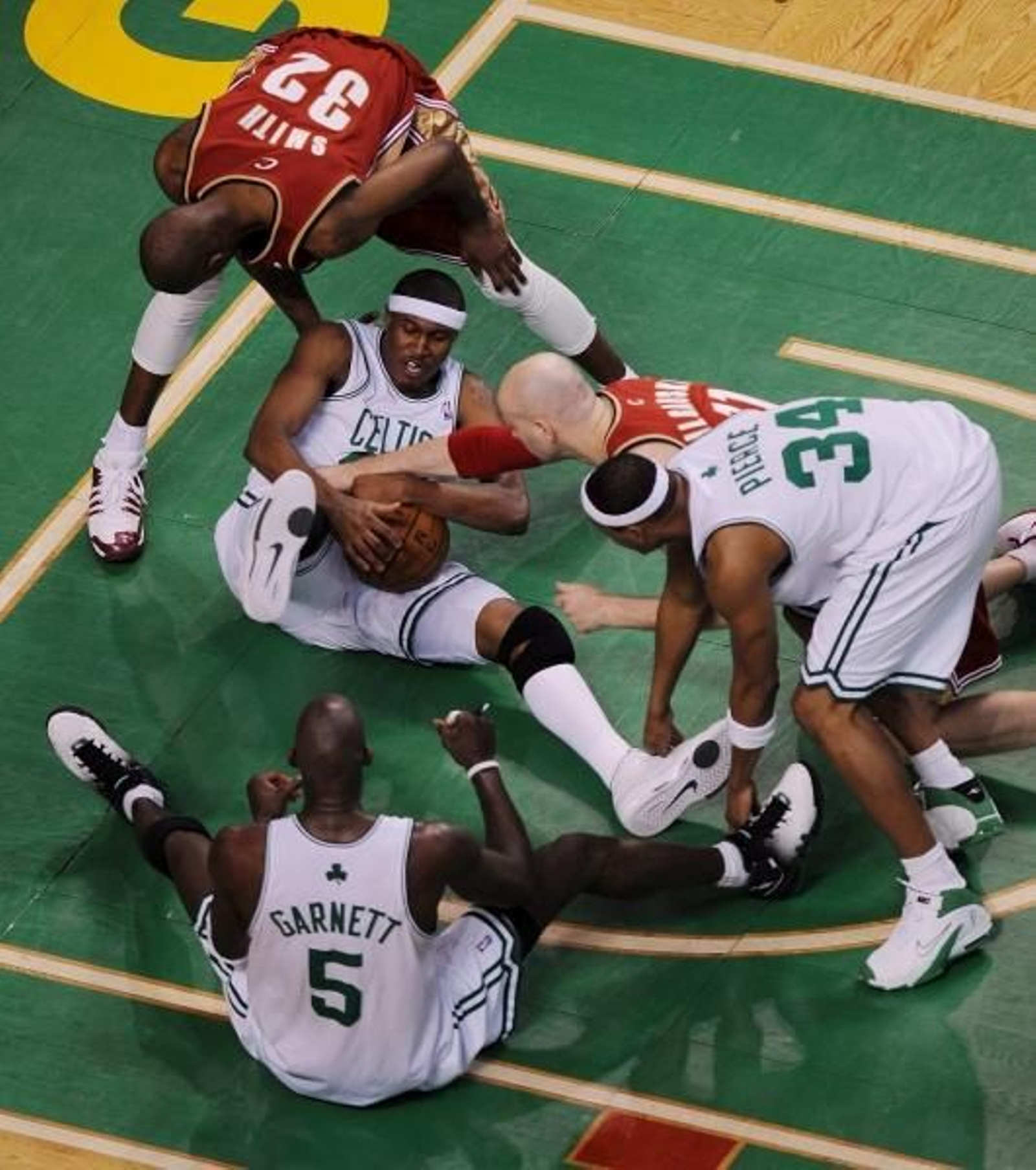 Varios jugadores en el suelo luchan por conseguir el balón. (Foto: Matt Campbell)