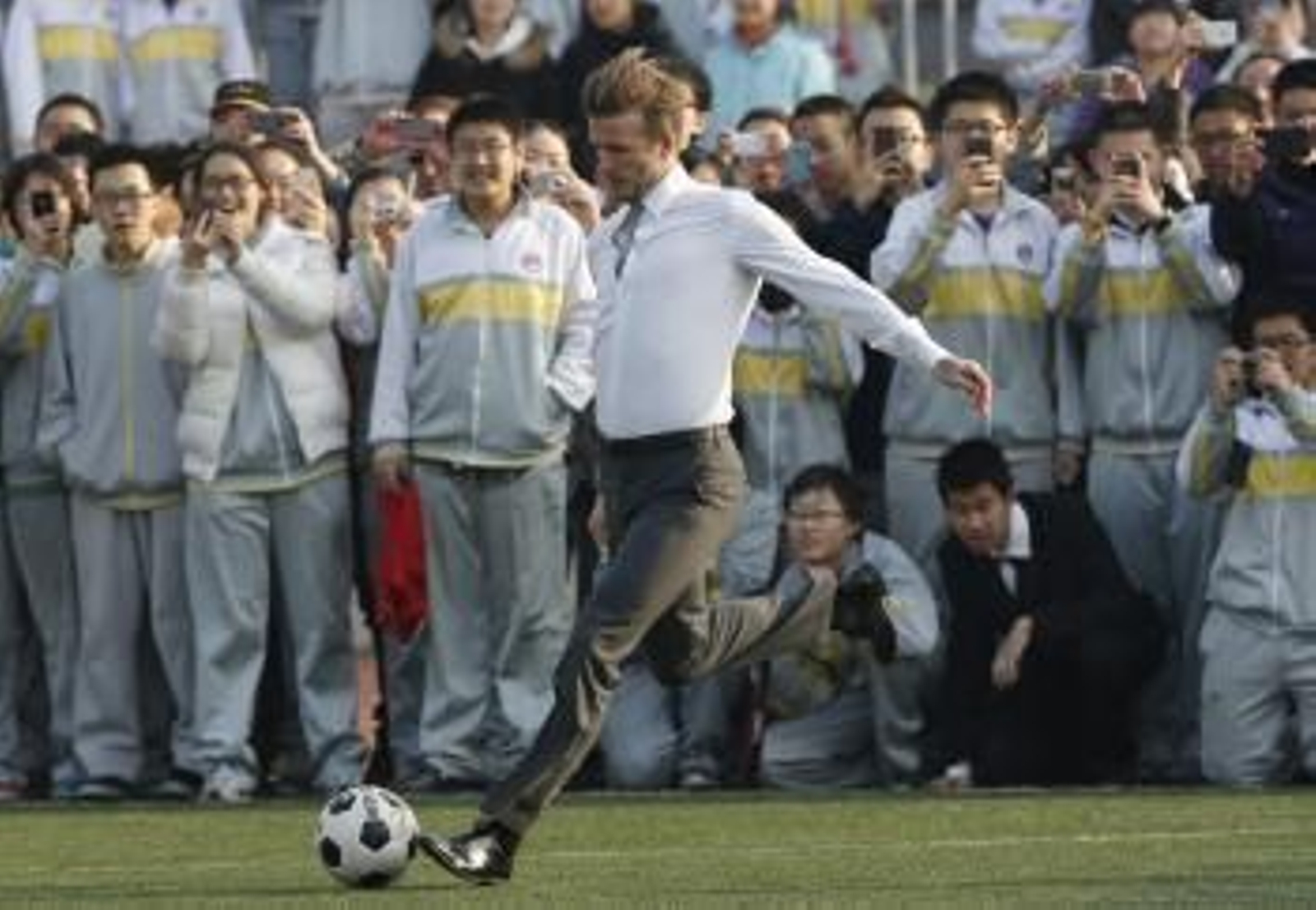 El futbolista británico David Beckham juega con estudiantes de un instituto en Pekín (China).