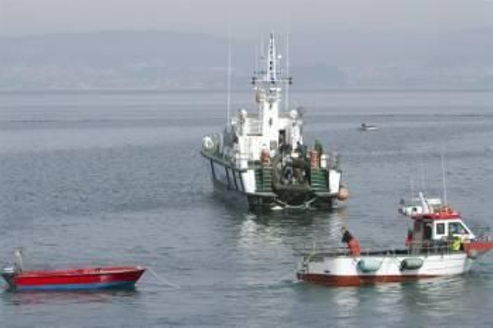 Un pesquero remolca al puerto de Bueu la barca en la que dos pescadores Francisco Pérez y Emilio Martínez han muerto ahogados tras volcar ésta cuando se encontraban realizando pesca deportiva en las inmediaciones de la Isla de Ons. Foto: EFE / Salvador Sa
