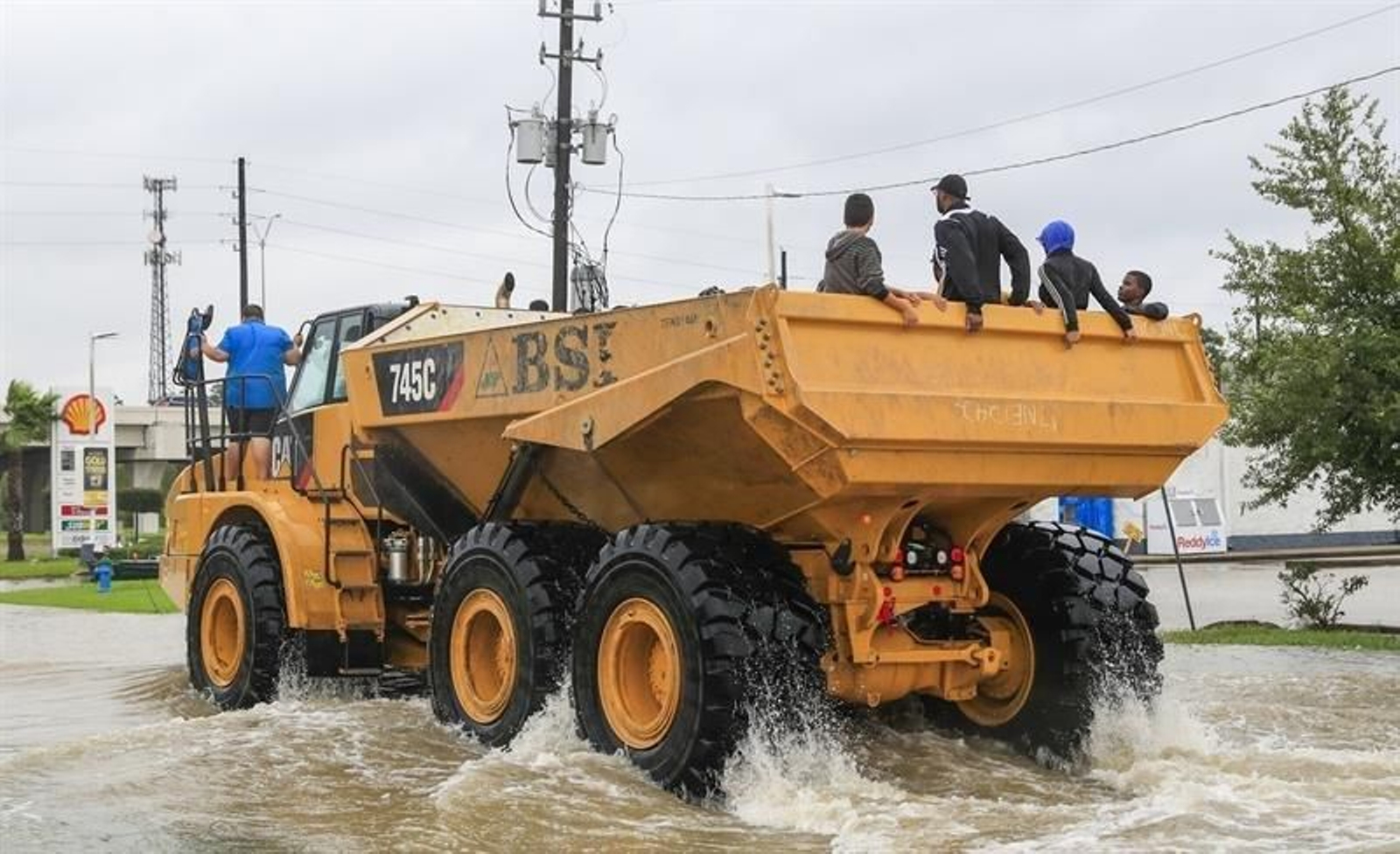Un camión de construcción pesada transporta a las víctimas de las inundaciones