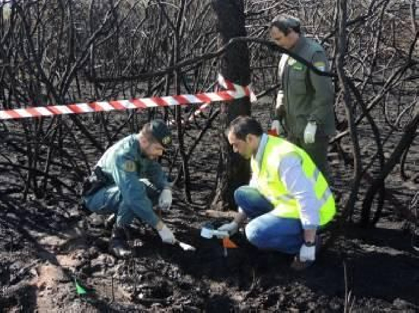 Tres investigadores toman muestras sobre uno de los incendios que se le imputan al detenido. (Foto: G.C.)