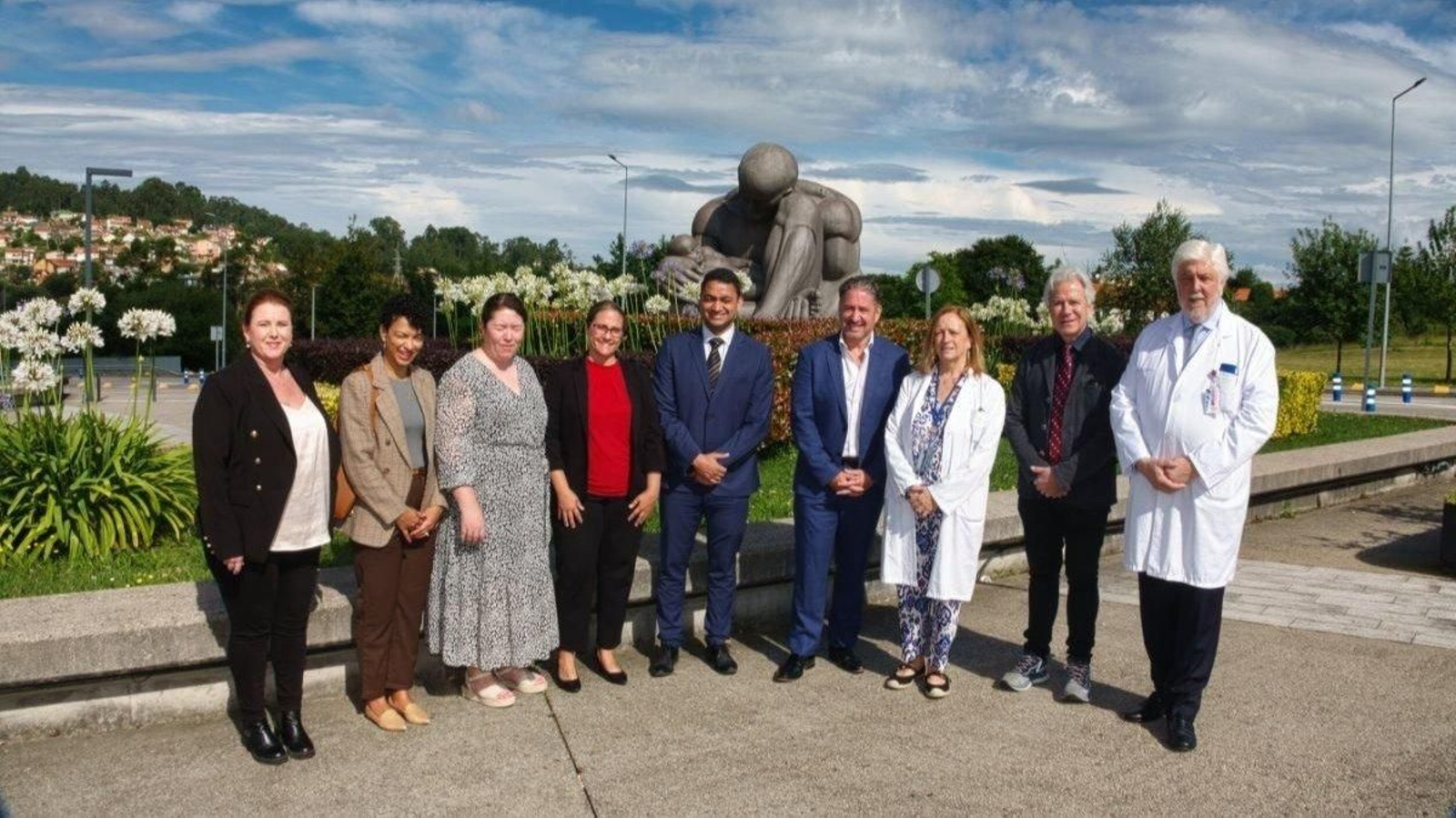 Los cardiólogos con Andrés Íñiguez y la directora médica, Esther Casal, ambos con bata, junto a la escultura del Titán.