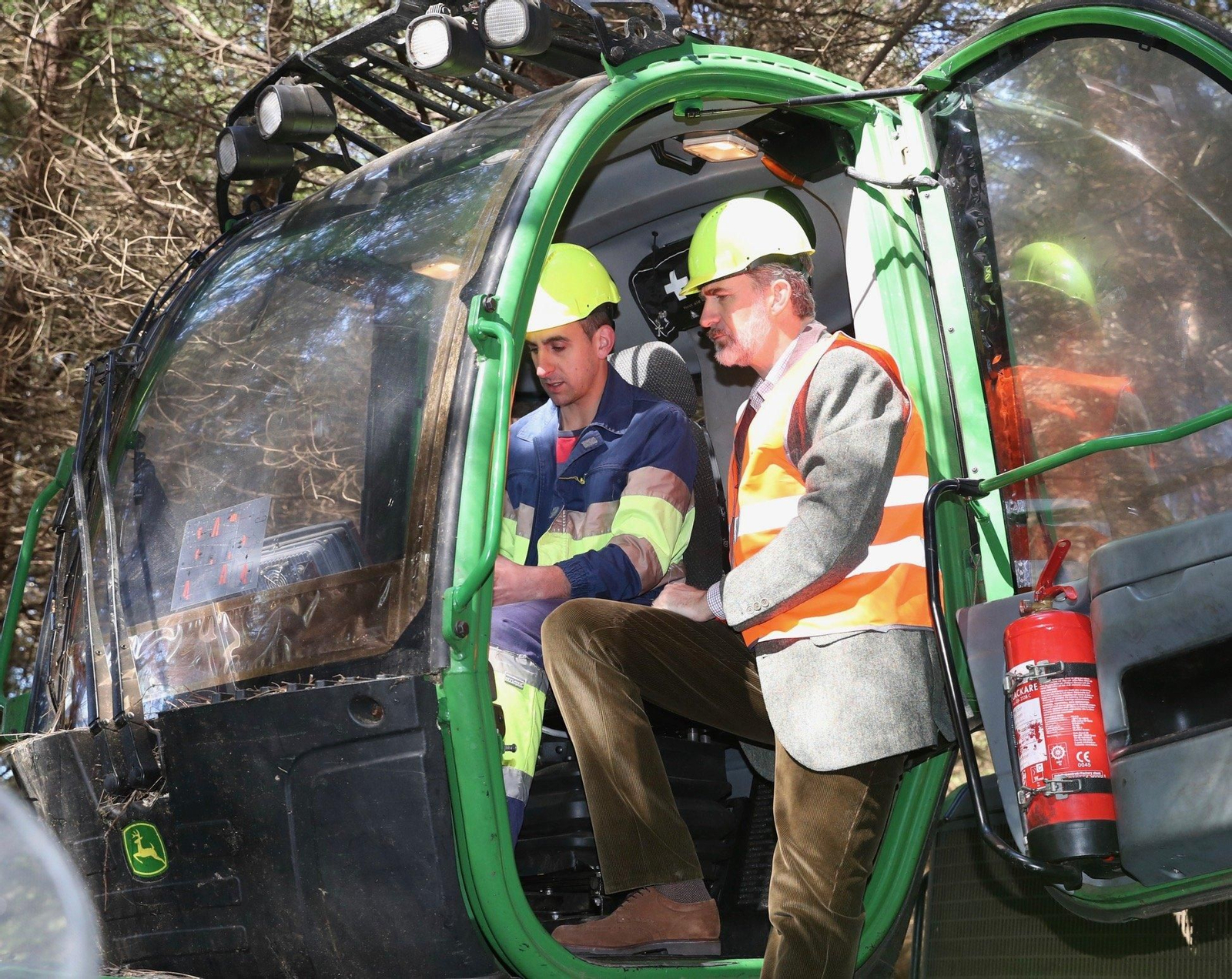 Felipe VI atiende las explicaciones de un trabajador sobre una de las máquinas robotizadas del sector forestal.