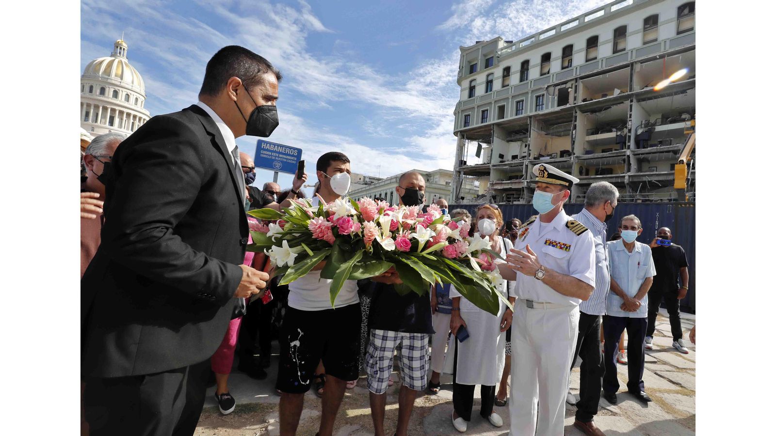 El embajador de España en Cuba, Ángel Martín Peccis (i), el capitán de navío Manuel García Ruiz (4-d), los hermanos del español herido (centro), y representantes de las diferentes sociedades españolas en Cuba, colocan una ofrenda floral frente al Hotel Saratoga, en La Habana (Cuba). EFE/Ernesto Mastrascusa
