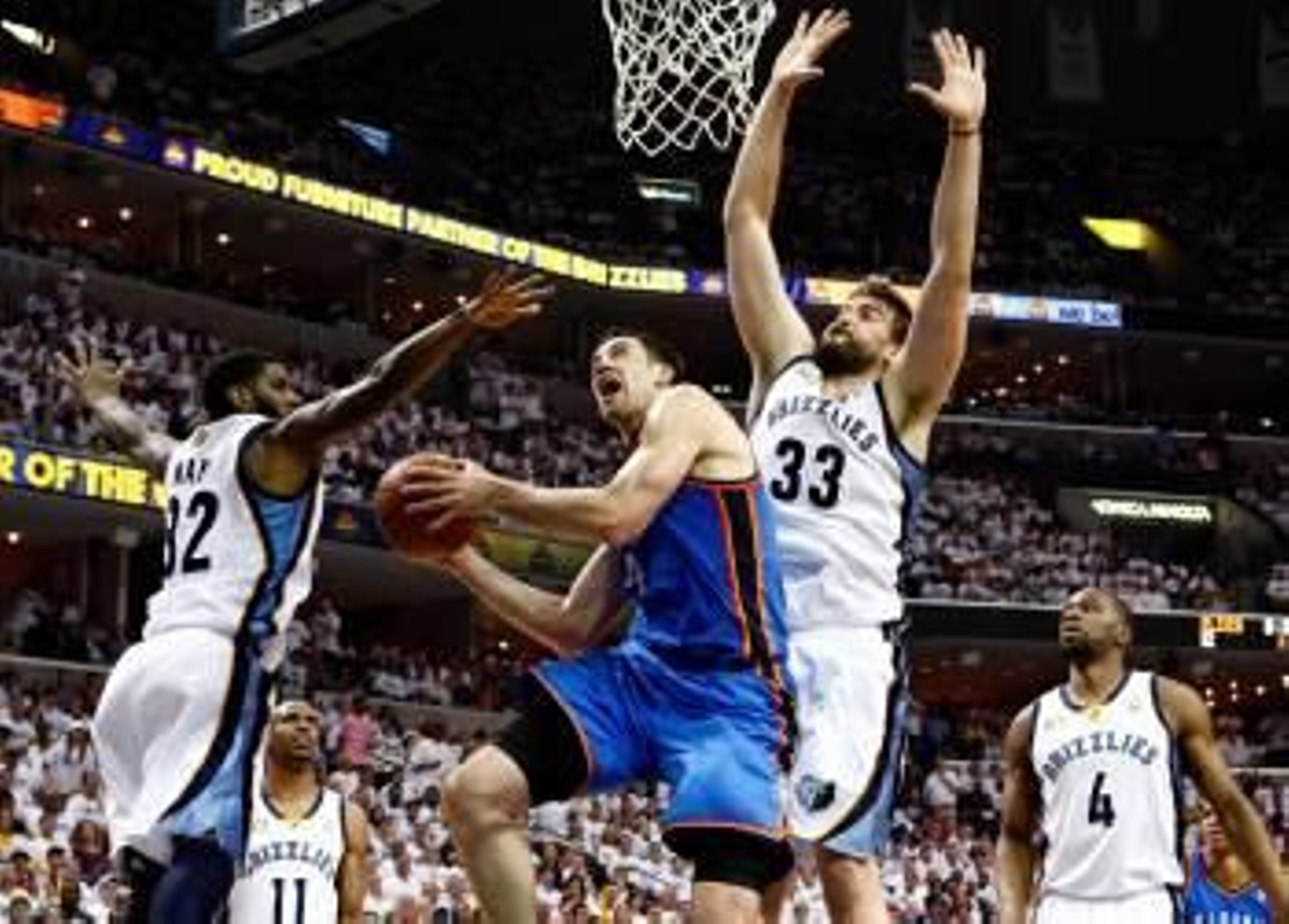 El jugador de los Thunder de Oklahoma City Nick Collison se dirige a la cesta ante O.J. Mayo y el español Marc Gasol. (Foto: MIKE BROWN)